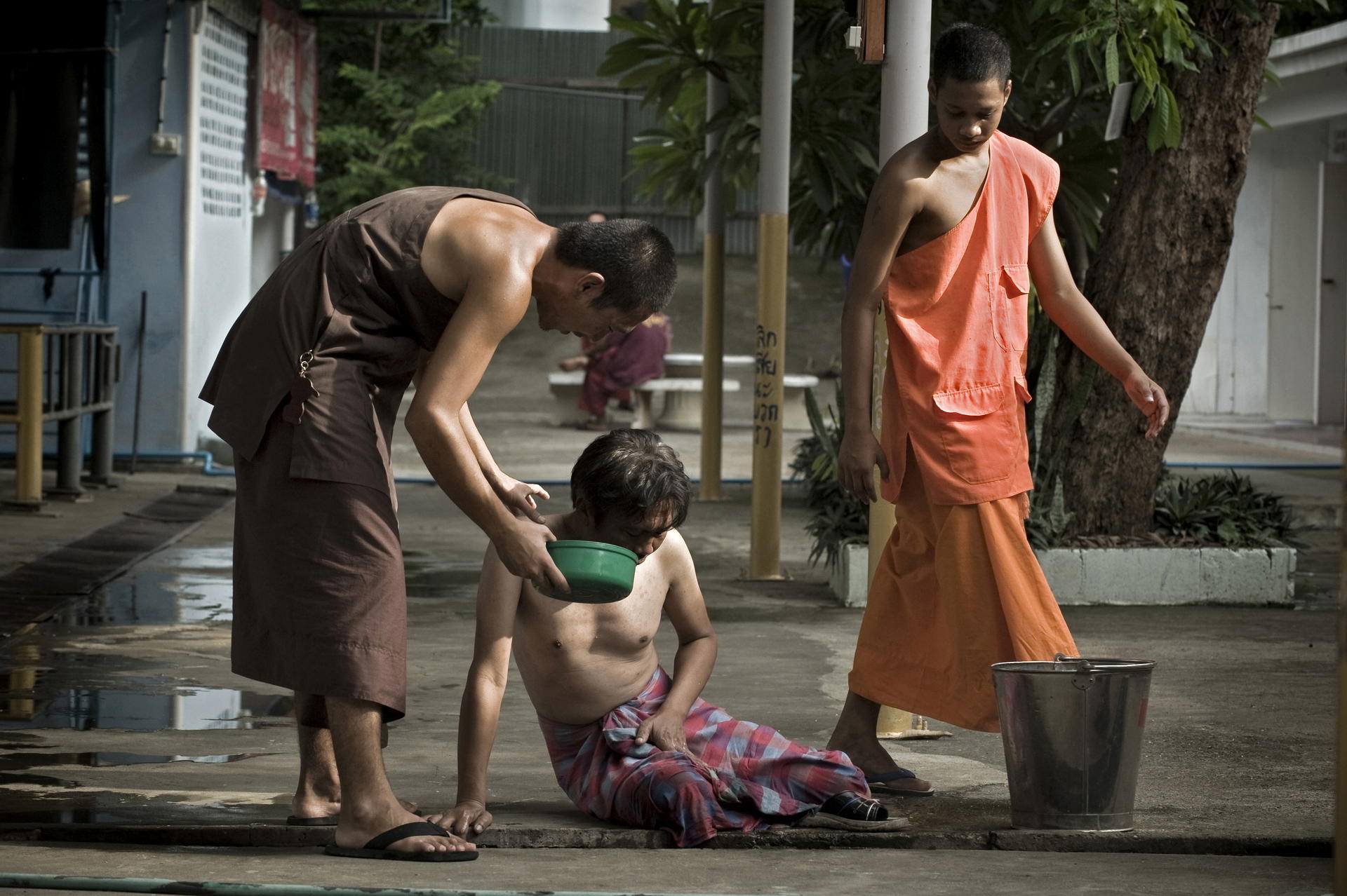 A monk comforts a patient who has taken the detox medicine. At Wat Thamkrabok, everyone vomits. Photos: AFP; Nathan Thompson