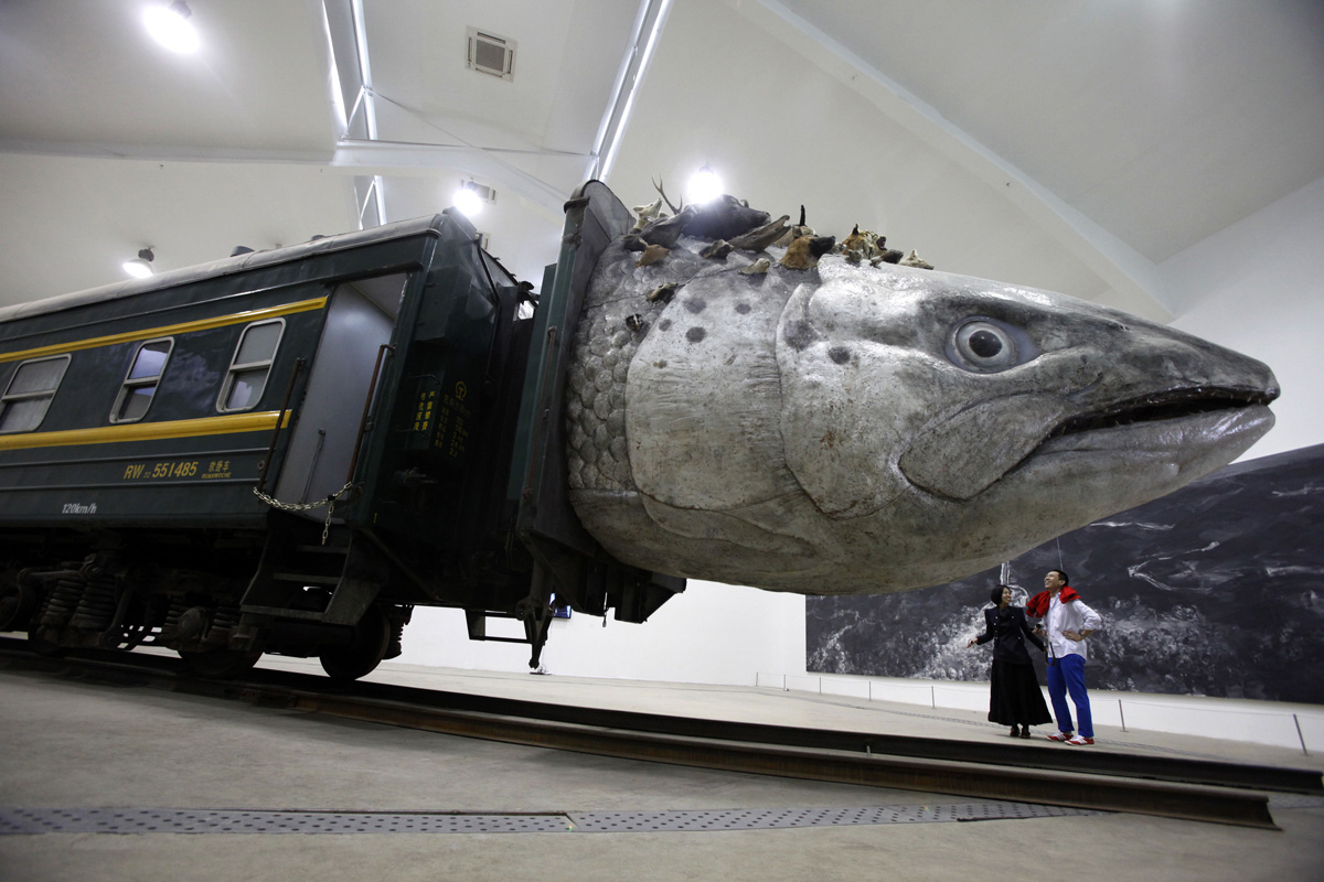 An installation art work entitled "Leviathanation" by Huang Yongping features a giant fish head made from fiberglass, stuffed animals and a train. Photo: AP