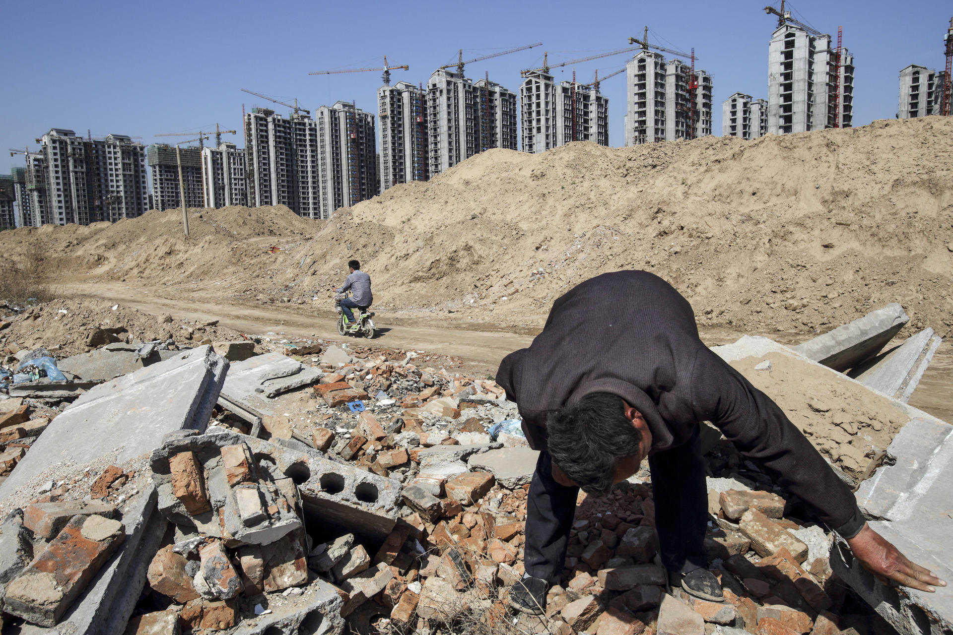 A 2013 image shows Li Rui scavenging for scrap metal where his village once was, in Liaocheng, Shandong province. Li was a farmer until six years ago, when the local government announced it would raze his village and turn farmland into an urban development zone.