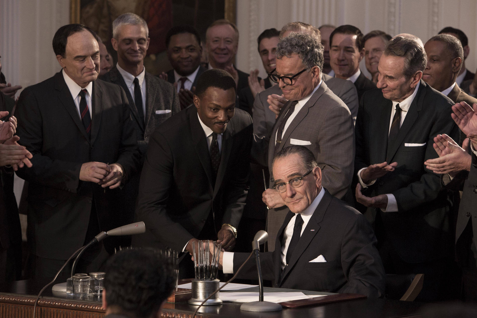 Martin Luther King (Anthony Mackie) shakes hands with Lyndon B. Johnson (Bryan Cranston, seated) in a still from All the Way.