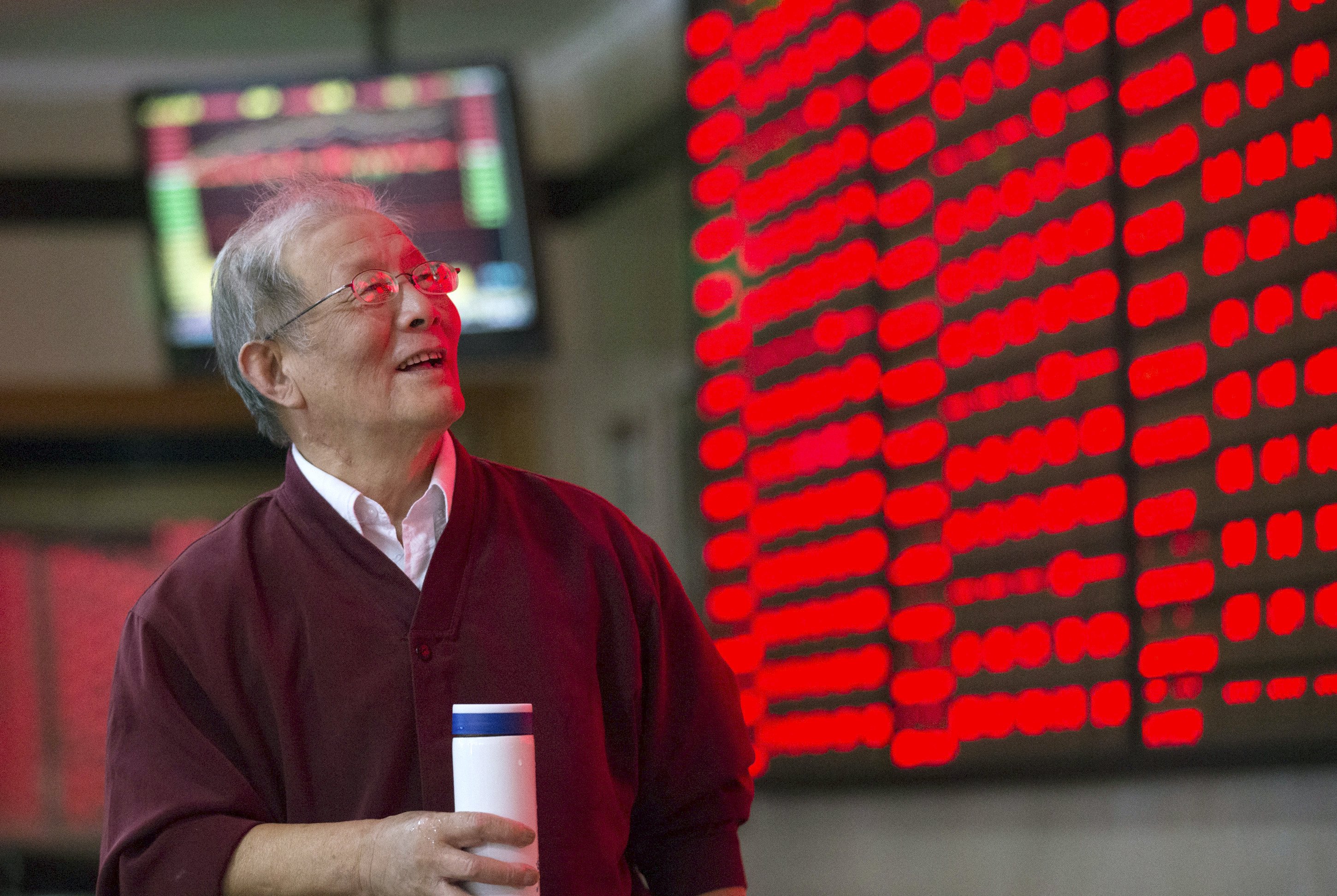 An investor looks at an electronic board showing stock information at a brokerage house in Nanjing, Jiangsu province, China, October 12, 2015. China shares jumped over 3 percent on Monday to their highest level in seven weeks after the central bank took fresh steps to inject liquidity into the struggling economy and said the stock market's correction "is almost over". REUTERS/China Daily CHINA OUT. NO COMMERCIAL OR EDITORIAL SALES IN CHINA.