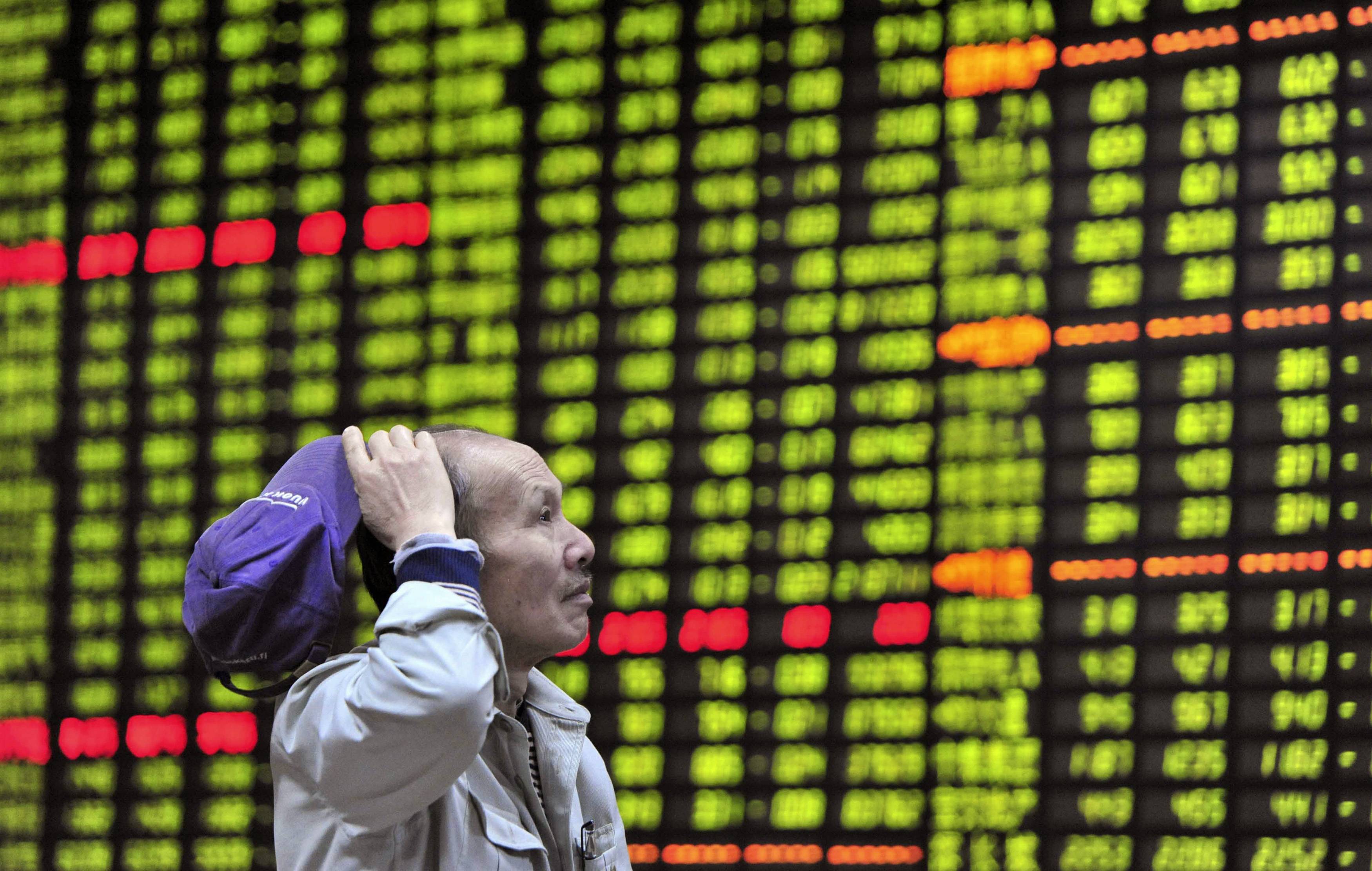 An investor looks at an electronic board showing stock information at a brokerage house in Jiujiang, Jiangxi province April 23, 2013. China shares posted their worst daily loss in nearly a month on Tuesday, weighing on Hong Kong markets, after a weak preliminary survey of Chinese manufacturing activity in April stoked fears of sluggish economic growth in the second quarter. REUTERS/Jon Woo (CHINA - Tags: BUSINESS) CHINA OUT. NO COMMERCIAL OR EDITORIAL SALES IN CHINA