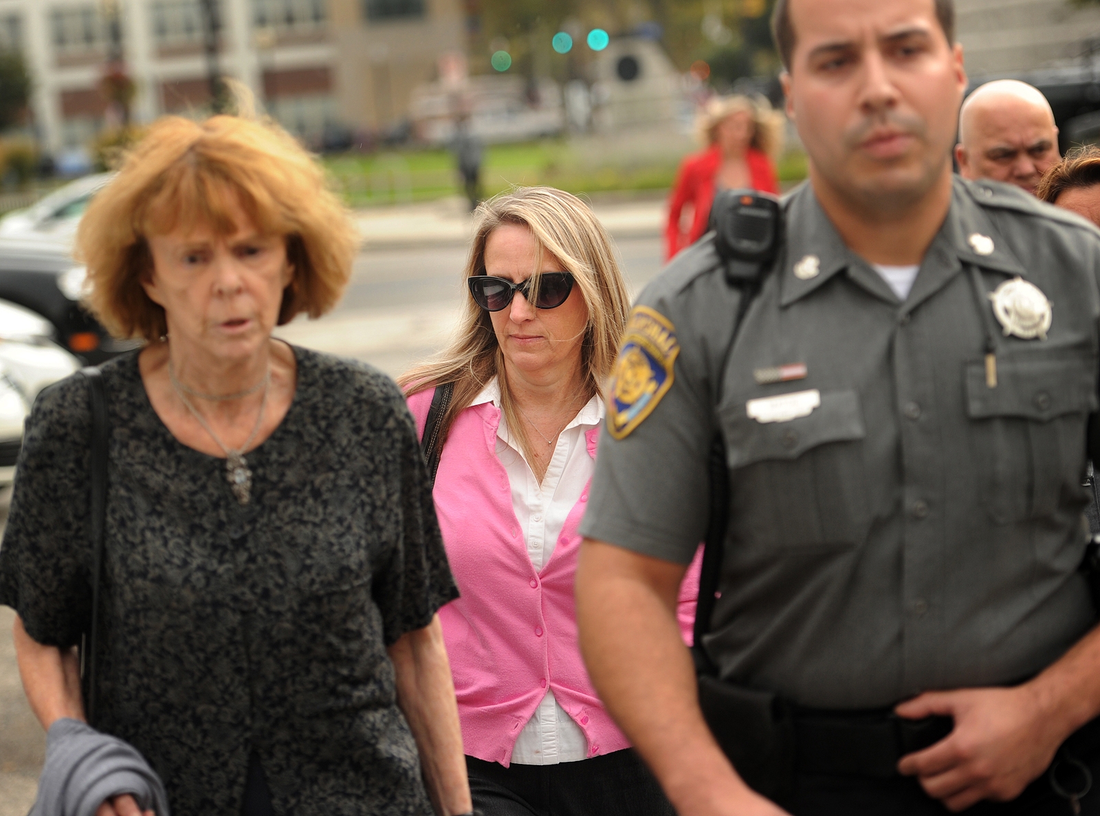 In this Tuesday, Oct. 13, 2015, photo, Jennifer Connell, center, is escorted to her car by marshals after her lawsuit against her Westport nephew was found in his favor in Superior Court in Bridgeport, Conn. She sued her nephew, who was eight-years-old at the time of the incident, for breaking her wrist after jumping into her arms at his birthday party. (Brian A. Pounds/Hearst Connecticut Media via AP) MANDATORY CREDIT