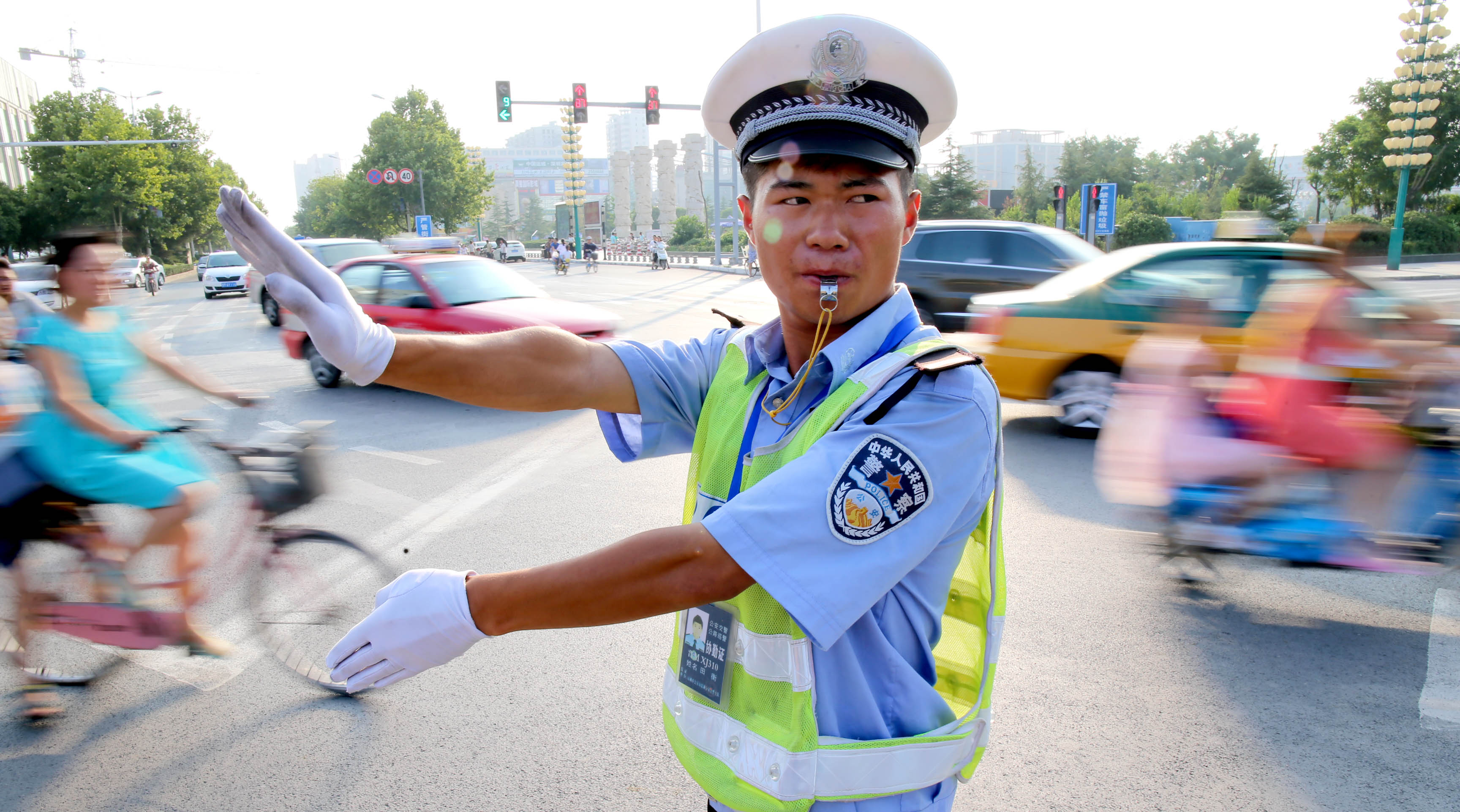 (140720) -- YUNCHENG, July 20, 2014 (Xinhua) -- A traffic policeman direct the traffic in Yuncheng City, north China's Shanxi Province, July 20, 2014. The National Meteorological Center (NMC) issued a yellow warning alert for heat on Sunday. (Xinhua/Bao Dongsheng) (zkr)