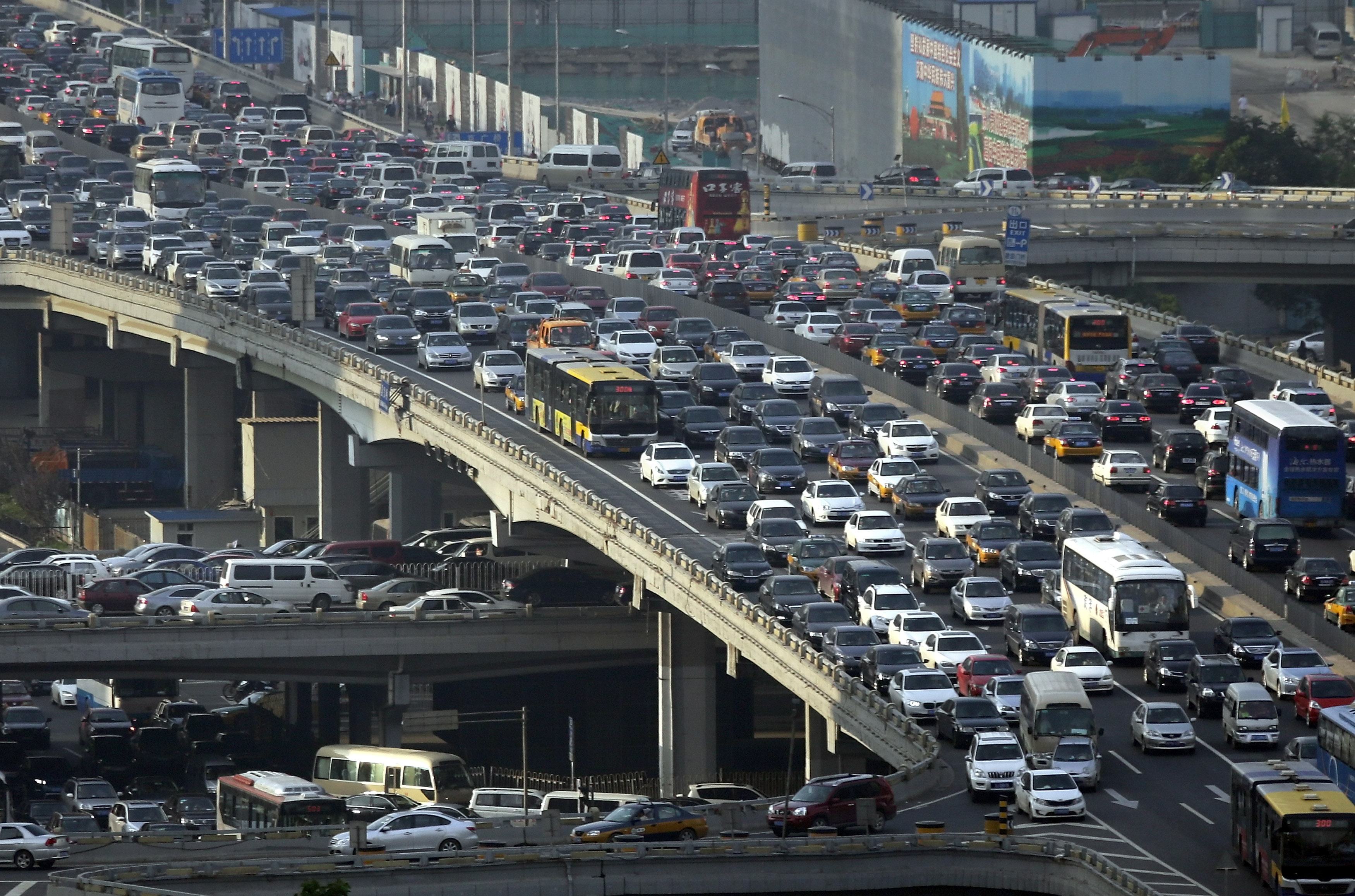Lines of cars are pictured during a rush hour traffic jam on Guomao Bridge in Beijing July 11, 2013. Eight more cities in China, the world's biggest auto market, are likely to announce policies restricting new vehicle purchases, an official at the automakers association said, as Beijing tries to control air pollution. REUTERS/Jason Lee (CHINA - Tags: TRANSPORT ENVIRONMENT BUSINESS TPX IMAGES OF THE DAY)