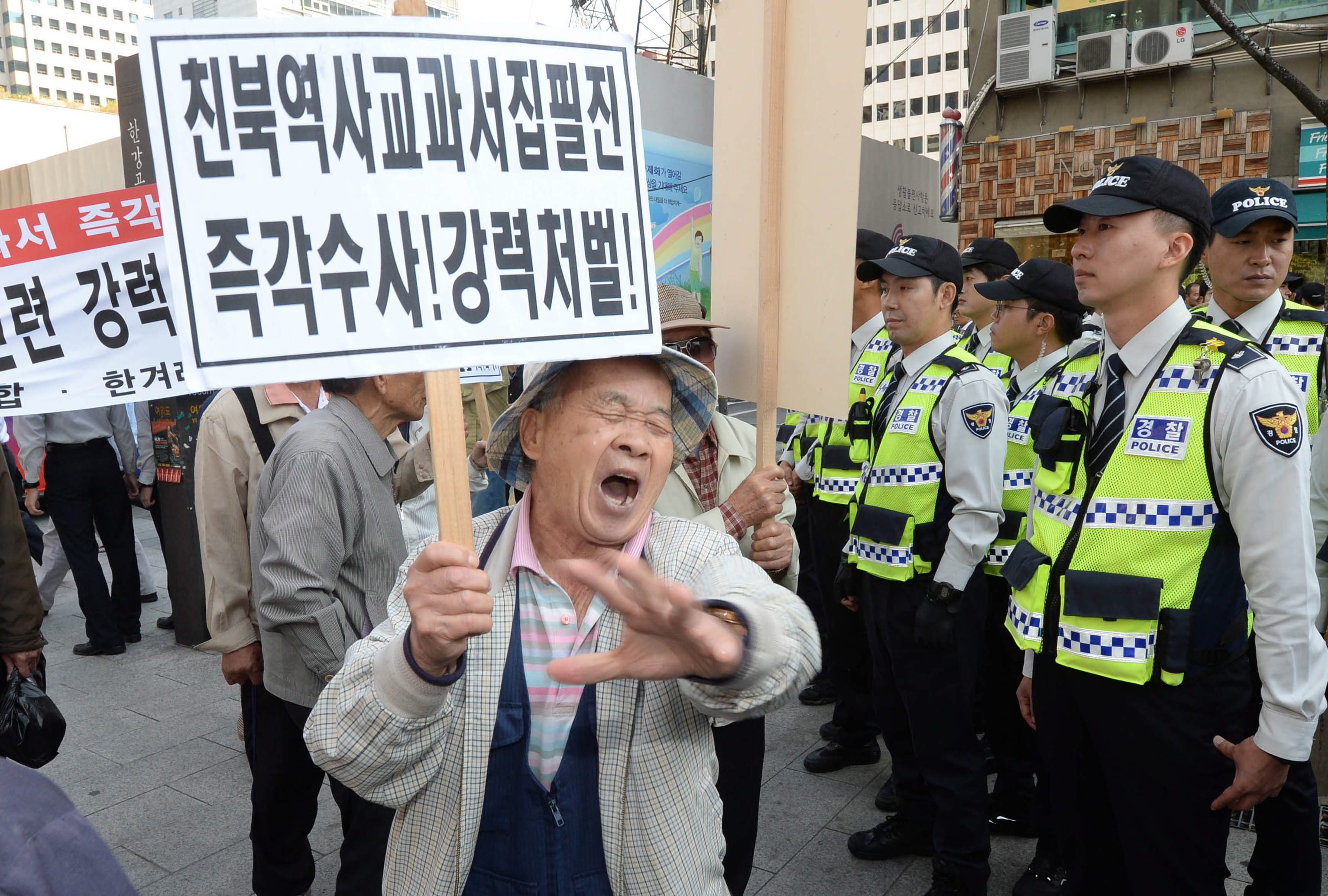 epa04975708 Members of a conservative group take part in a rally in Seoul, South Korea, 13 October 2015, to express their support for the government's plan to reintroduce a single state history textbook for secondary school students and foil a petition campaign led by the main opposition New Politics Alliance for Democracy for the scrapping of the plan. The government has said the plan is to address what it calls the predominantly left-leaning contents in current books, but progressive students, scholars and the opposition bloc claim it will stamp out diverse views and distort facts. The placard in Korean reads 'immediate investigation needed and stronger punishment for pro North Korea history textbook writing staff.' EPA/YONHAP SOUTH KOREA OUT