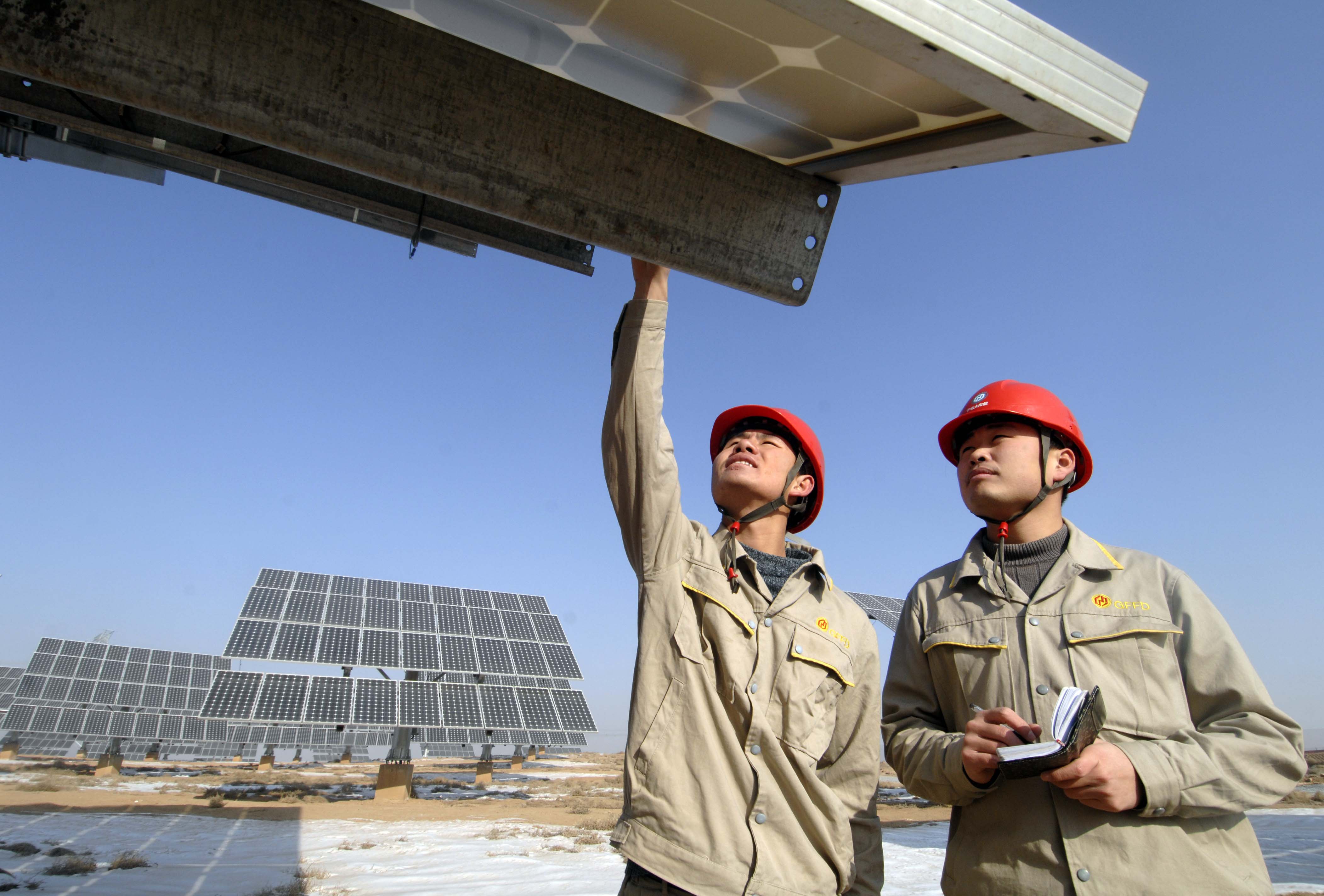 (111229) -- YINCHUAN, Dec. 29, 2011 (Xinhua) -- Working staff check the condition of solar panel in Hongsibao PV Power Station of Ningxia Electric Power Group, northwest China's Ningxia Hui Autonomous Region, Dec. 28, 2011. With the investment of 2.3 billion yuan (364 million U.S dollars), Ningxia Electric Power Group has established 6 grid-connected PV power stations with an installed capacity of 103.33 megawatts. The total generation capacity has reached 62.55 million kwh. (Xinhua/Peng Zhaozhi) (mp)