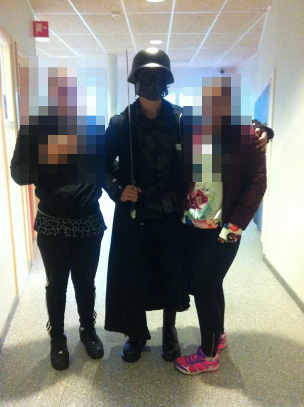 This picture made available to AFP by a student shows the masked man armed with a sword posing for a photo with two other students before attacking students and staff at the primary and middle school in Trollhattan, southwestern Sweden, on October 22, 2015. The man brandishing a sword broke into a school in Sweden, killing two people and seriously wounding two others before being shot by police. AFP PHOTO +++ RESTRICTED TO EDITORIAL USE