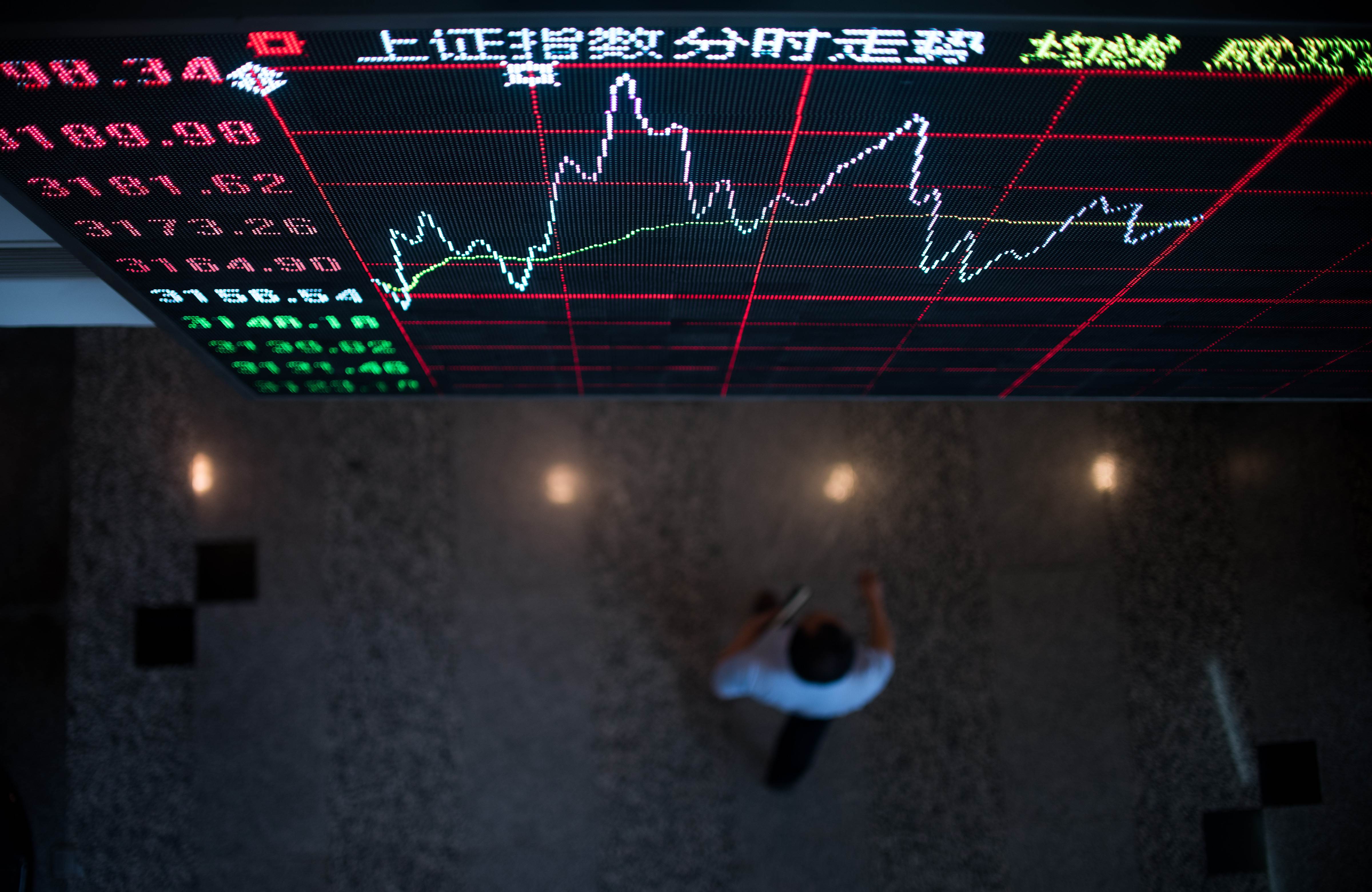 A man speaks to another investor in front of an electronic board showing stock information at a brokerage house in Hangzhou, Zhejiang province, China, September 25, 2015. China stocks fell on Friday, led by a selloff in small caps, as the main indexes ended the week roughly flat in shrinking trading volume. REUTERS/China Daily CHINA OUT. NO COMMERCIAL OR EDITORIAL SALES IN CHINA