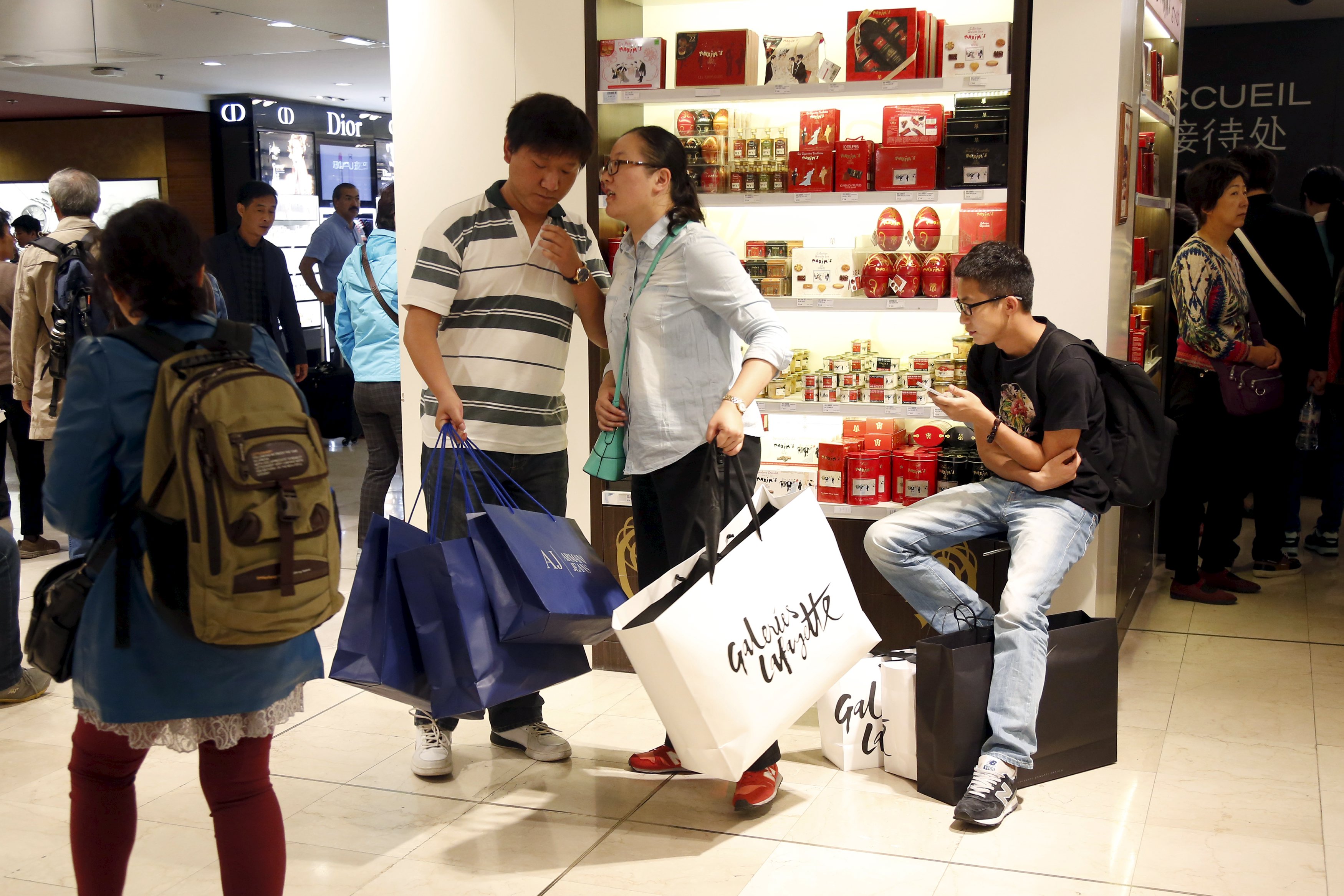 Customers visit the Galeries Lafayette department store in Paris, France, September 23, 2015. Chinese luxury consumers are spending more on ready-to-wear and new labels, a notable shift in the behaviour and tastes of the world's top spenders, a Reuters survey of retailers in the United States, Asia and Europe showed. Analysts estimate more than two thirds of luxury purchases by Chinese buyers is done overseas, mainly in shopping hotspots such as Paris, Milan, London, New York and Tokyo, which can offer savings of more than 50 percent compared with China prices thanks to foreign exchange rates, tax refunds and other discounts. To Match Insight LUXURY-CHINA/ Picture taken September 23, 2015. REUTERS/Charles Platiau