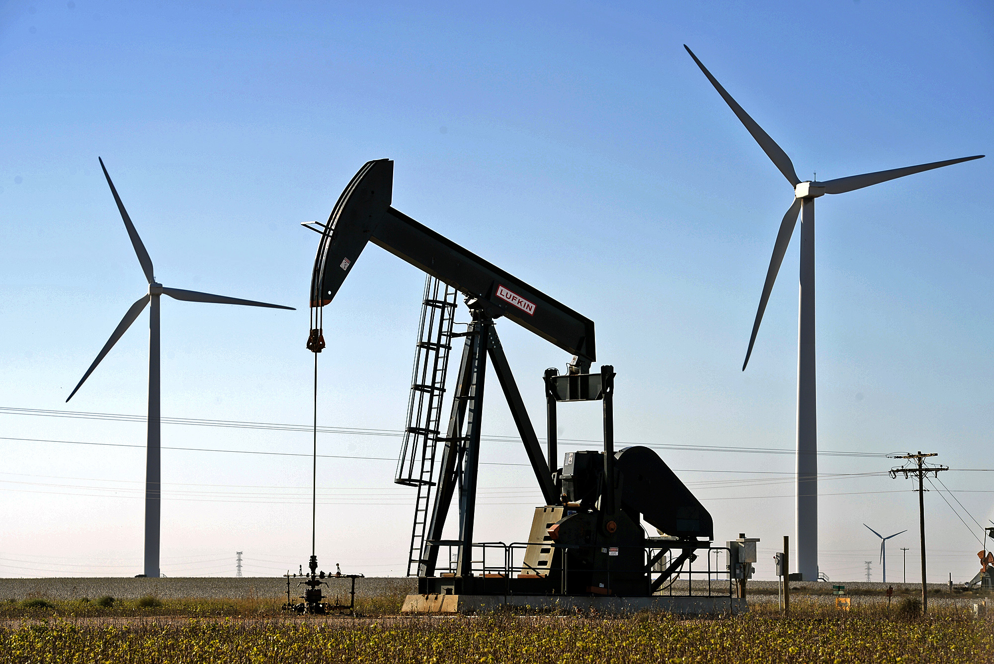 Wind turbines and an oil pumpjack work Tuesday, Oct. 27, 2015, north of Stanton, Texas. (James Durbin/Midland Reporter-Telegram via AP)