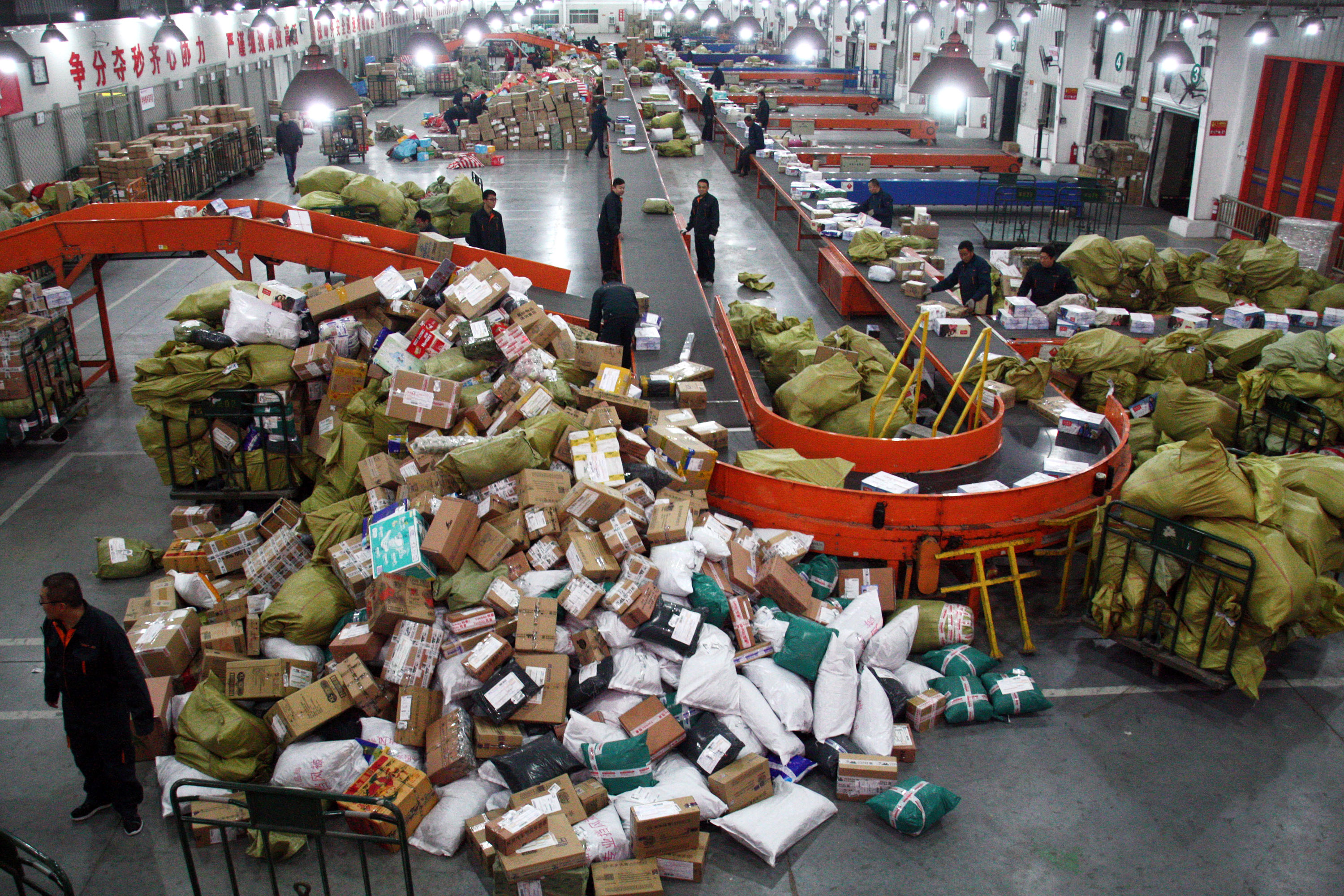 (150107) -- WEIFANG, Jan. 7, 2015 (Xinhua) -- File photo taken on Nov. 13, 2014 shows couriers sorting parcels at an express facility in Weifang, east China's Shandong Province. The total revenue of China's express delivery market hit 204 billion yuan (33 billion U.S. dollars) in 2014, up 42 percent, official data showed on Tuesday. Businesses made 14 billion deliveries last year, the most in the world and 52 percent up from 2013, according to the State Post Bureau (SPB). (Xinhua/Guo Zhihua) (wyo)