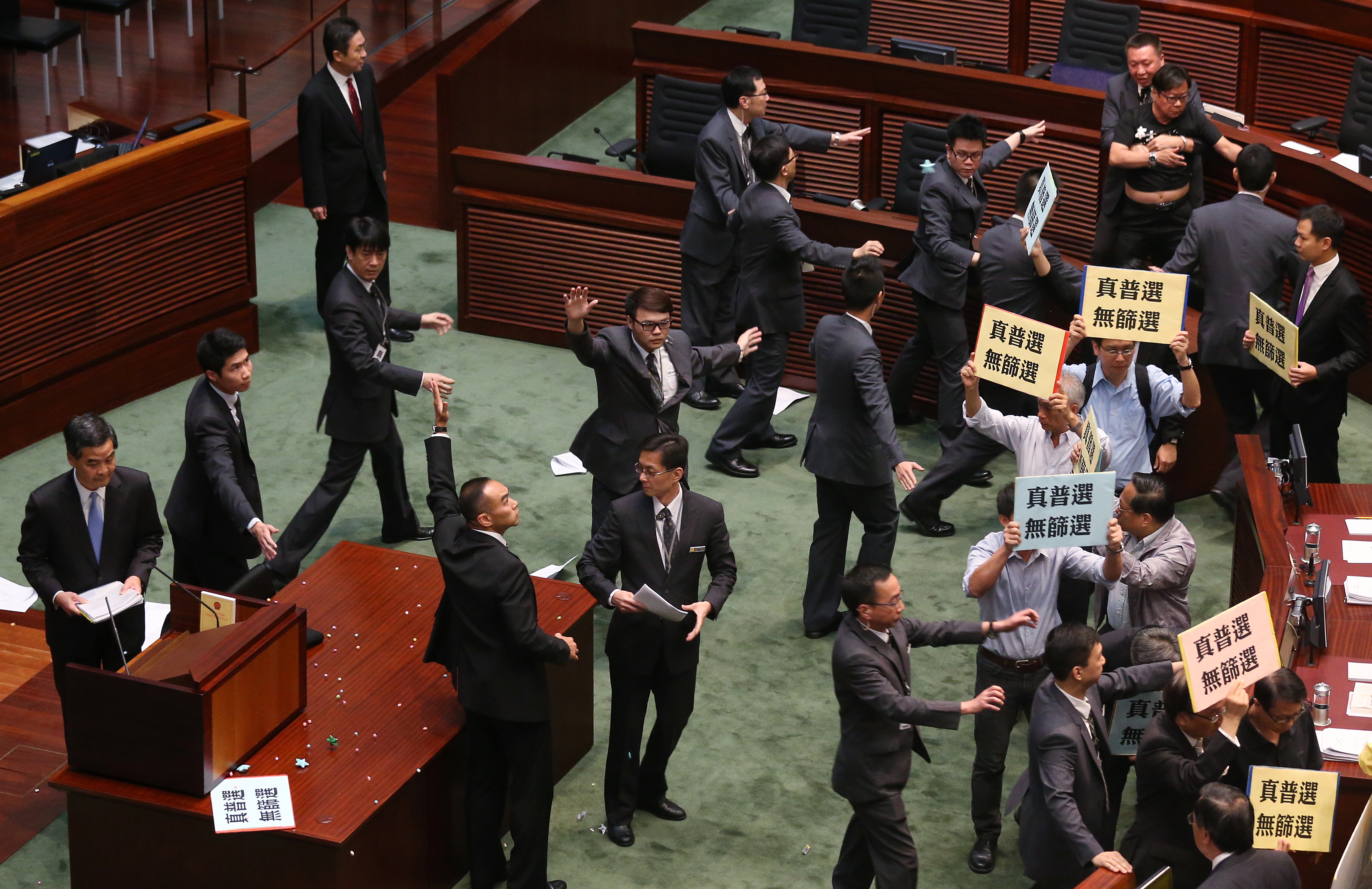 Lawmaker Wong Yuk-man (top, 3rd right) throws a glass and documents to Chief Executive Leung Chun-ying during Chief Executive Question and Answer Session at Legco Building in Tamar. 03JUL14