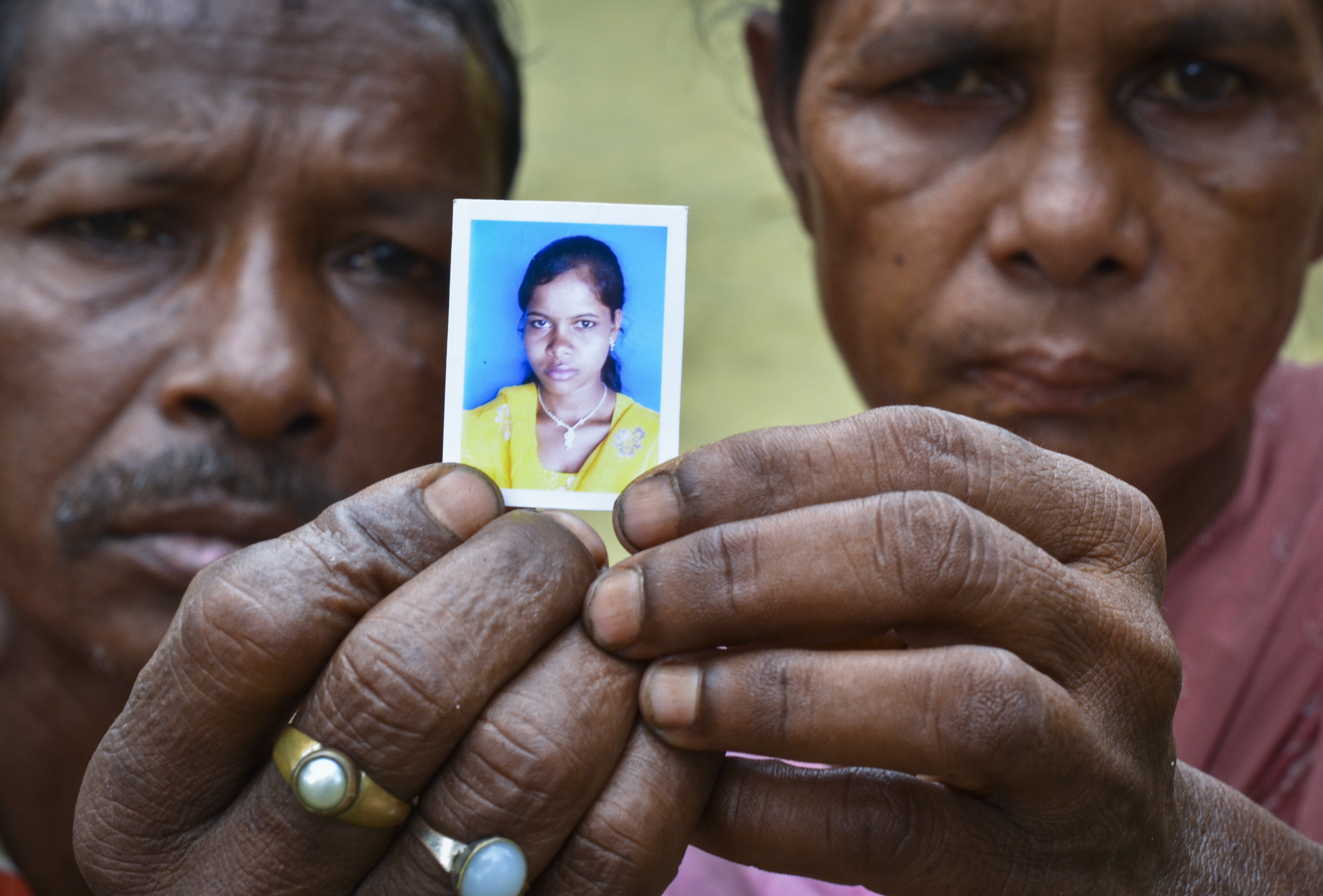 This image taken on June 20, 2013 shows Arjun Tati, 55, and Mukti Tati, 50, with a picture of their daughter Binita Tati, who was trafficked to Delhi from Laluk, Lakhimpur district, Assam, at the age of 14. Tati would now be 17, but her distraught parents have not seen her since. Tens of thousands of girls as young as 12 are trafficked from India‚Äôs remote north east every year. Many are the daughters of tea estate workers, whose low pay means they are unable to afford to look after their families. They end up working as servants in the Indian capital New Delhi or trafficked on to the Middle East and the UK. Many suffer physical and sexual abuse at the hands of employers who keep them locked up in their homes. Few receive the wages they were promised. The trade is driven by the low wages paid to tea plantation workers, who cannot afford to keep their daughters. 20JUN13 (SCMP 04AUG POST MAG)
