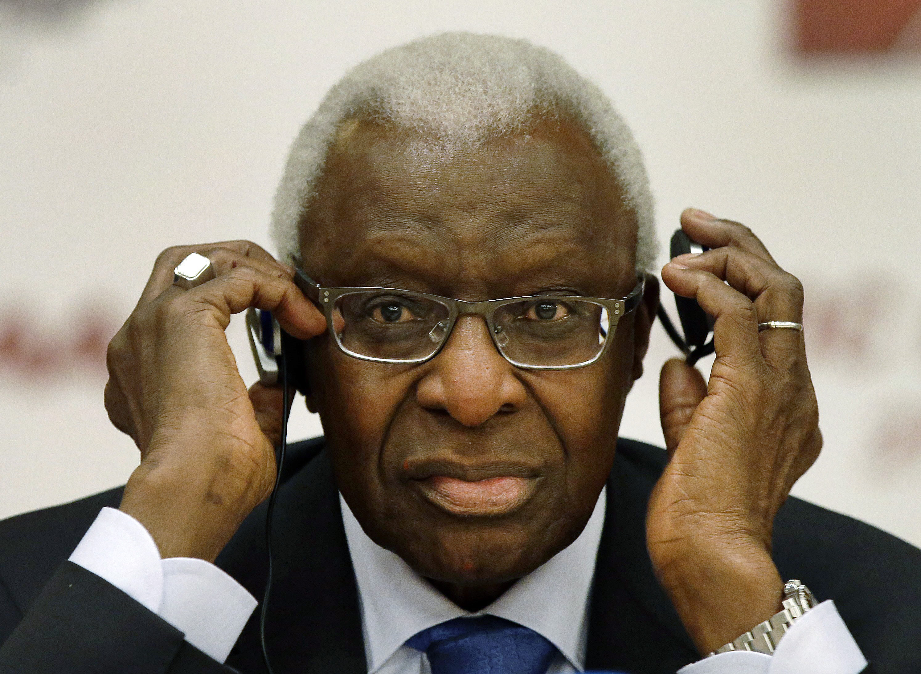 FILE - In this Aug. 21, 2015 file photo IAAF president Lamine Diack adjusts his headphones during a joint IOC and IAAF press conference on the side of the World Athletic Championships in Beijing. IOC ethics panel recommends provisional suspension of Lamine Diack as honorary member, Monday, Nov. 9, 2015. (AP Photo/Kin Cheung, file)