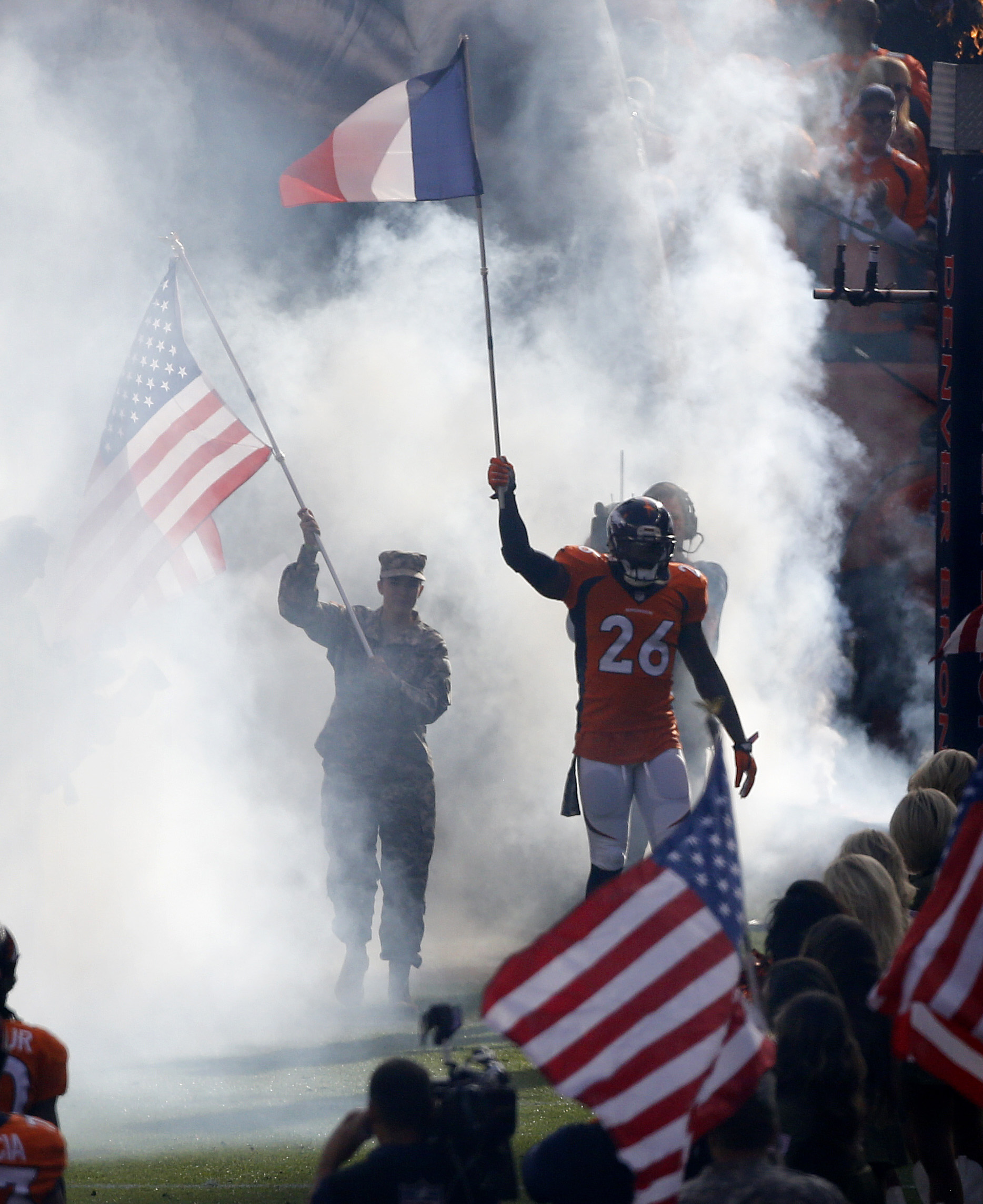 Denver Broncos free safety Darian Stewart (26) carries the French Flag as he takes the field prior to an NFL football game against the Kansas City Chiefs, Sunday, Nov. 15, 2015, in Denver. (AP Photo/Brennan Linsley)