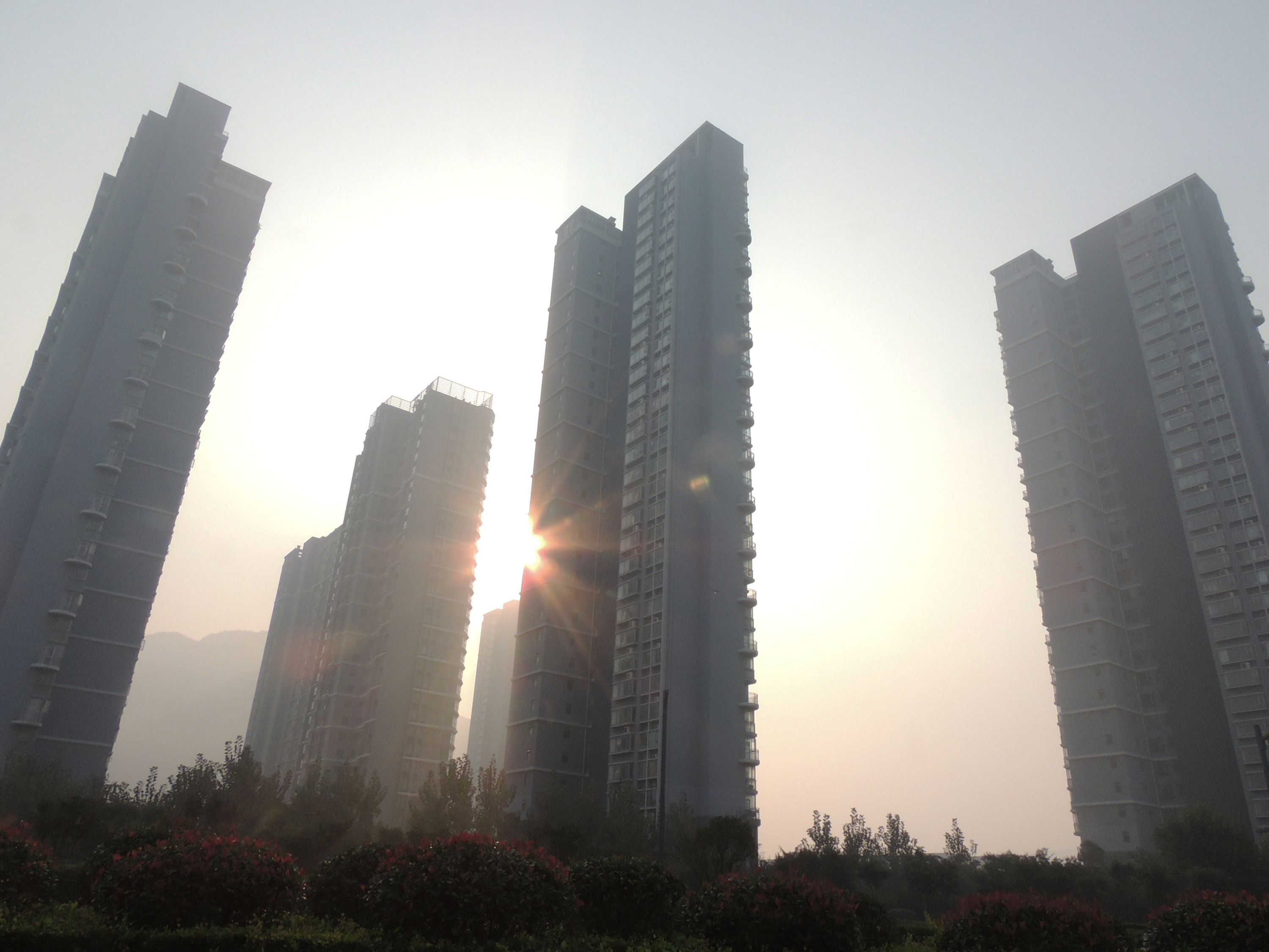 This picture taken on October 18, 2015 shows buildings in a residential district covered with smog in Lianyungang, east China's Jiangsu province. China's economic growth slowed to 6.9 percent in the third quarter, authorities in the world's second-largest economy said on October 19, as global markets worry about its prospects. CHINA OUT AFP PHOTO