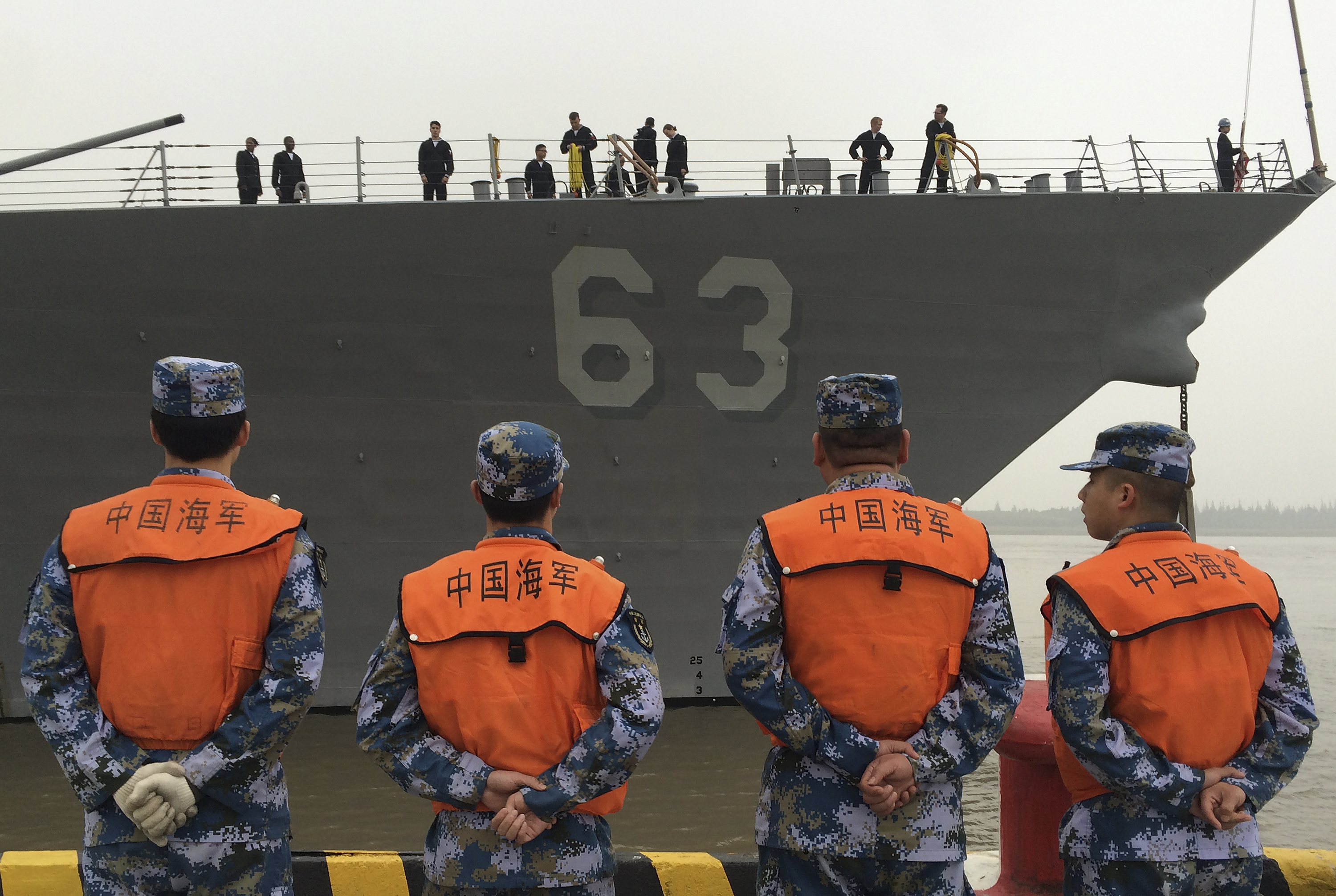 Chinese Navy personnel stand watch the guided missile destroyer USS Stethem arrives at the Shanghai International Passenger Quay for a scheduled port visit in Shanghai, China, Monday, Nov. 16, 2015. A U.S. Navy destroyer docked in Shanghai on Monday in a sign that contacts between the U.S. and Chinese militaries are continuing despite tensions over the South China Sea. (AP Photo/Paul Traynor)