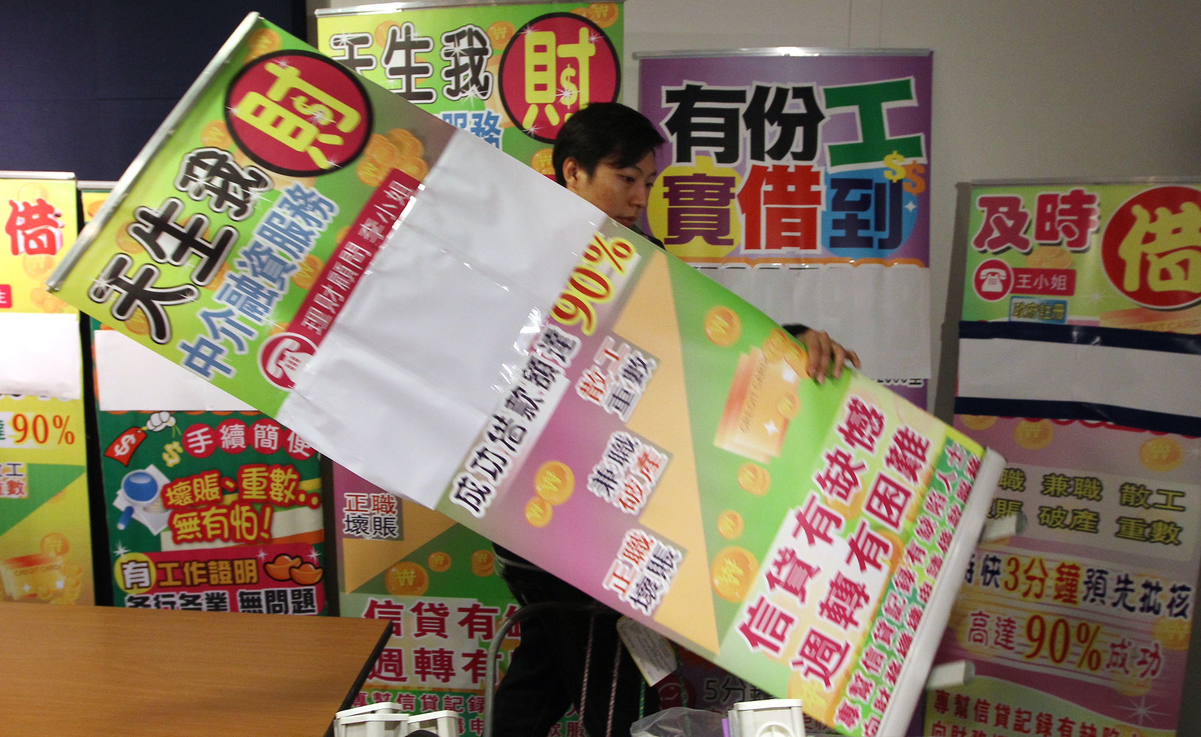A police removes the promotional banners confiscated from the operation during the press briefing on a police operation to raid money lending agencies. Pictured at Police Headquarter at Wan Chai. 14NOV12
