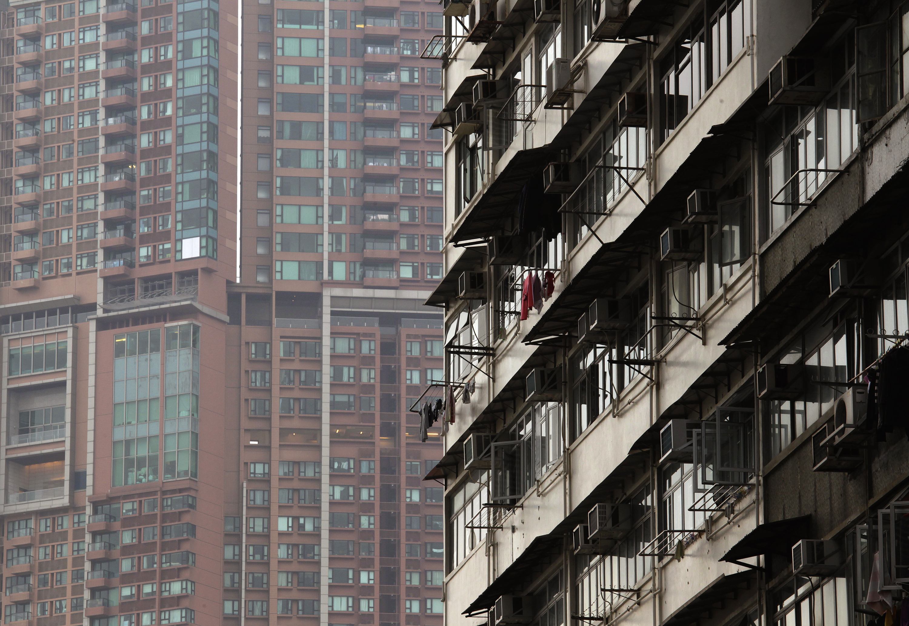 An old residential building is seen in front of The Arch, a luxury high rise apartment, at Hong Kong's West Kowloon district January 15, 2013. Singapore and Hong Kong now have identical 15 percent levies to slow the foreign money that has added fuel to their overheated property markets - measures that will help first-time buyers but throw the spotlight on investors' next targets. The curbs on residential real estate purchases could shift demand to retail and industrial spaces, diverting billions of dollars to those sectors as well as to housing markets in the United States, Canada, Australia and Malaysia. Picture taken January 15, 2013. REUTERS/Bobby Yip (CHINA - Tags: REAL ESTATE BUSINESS)