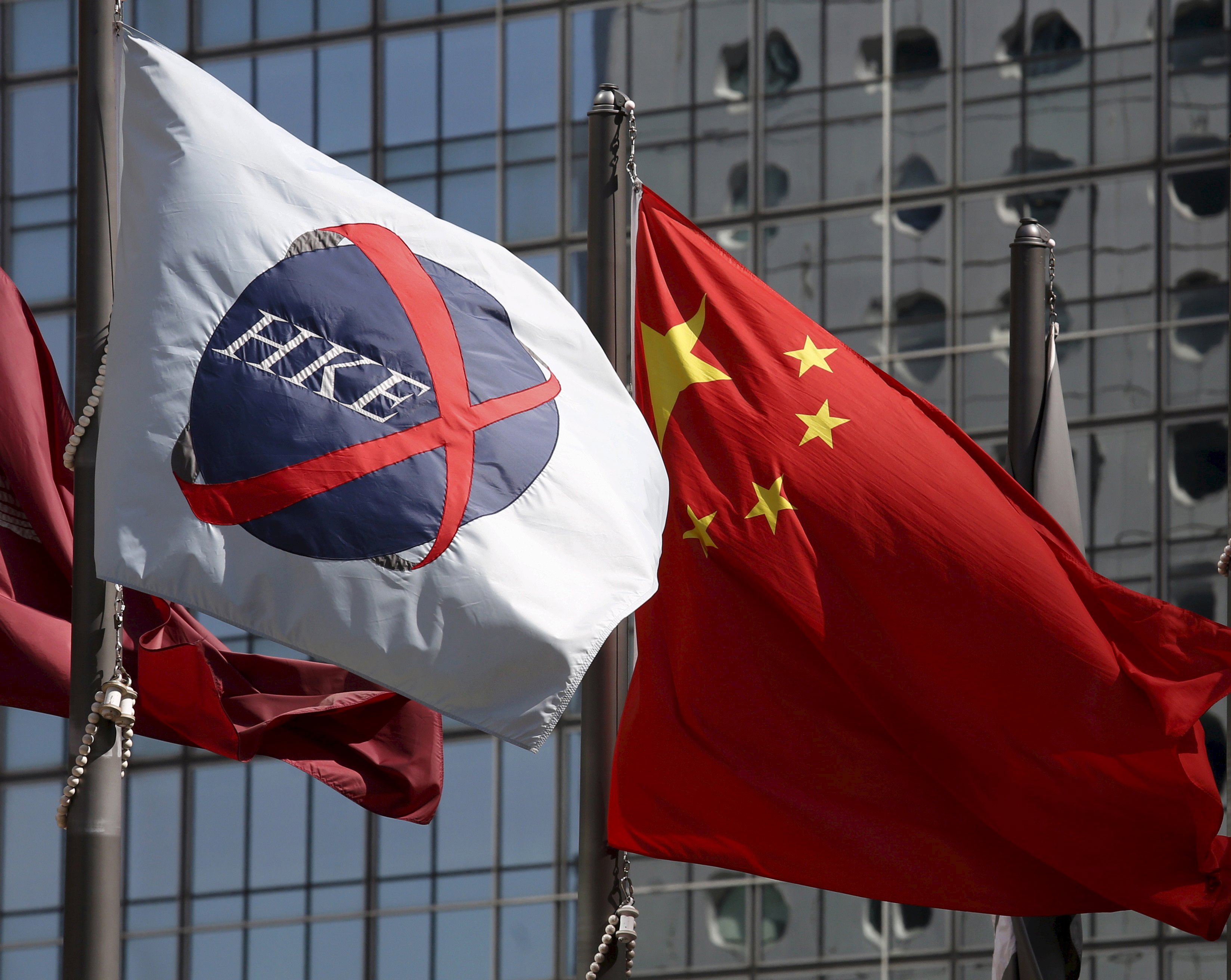 A Chinese national flag (R) flies beside a flag of the Hong Kong Exchanges (HKEx) in Hong Kong in this April 15, 2015 file photo. Following Chinas stock markets heavy fall in July, hundreds of companies and executives that answered the call from Beijing to do their patriotic duty and signal confidence by buying back their own stock, which regulators hoped would entice other investors back to trade are facing substantial losses as markets slid further. According to a Reuters analysis, firms that announced buybacks have seen their shares lose an average of roughly 40 percent in the last three months. REUTERS/Bobby Yip/Files