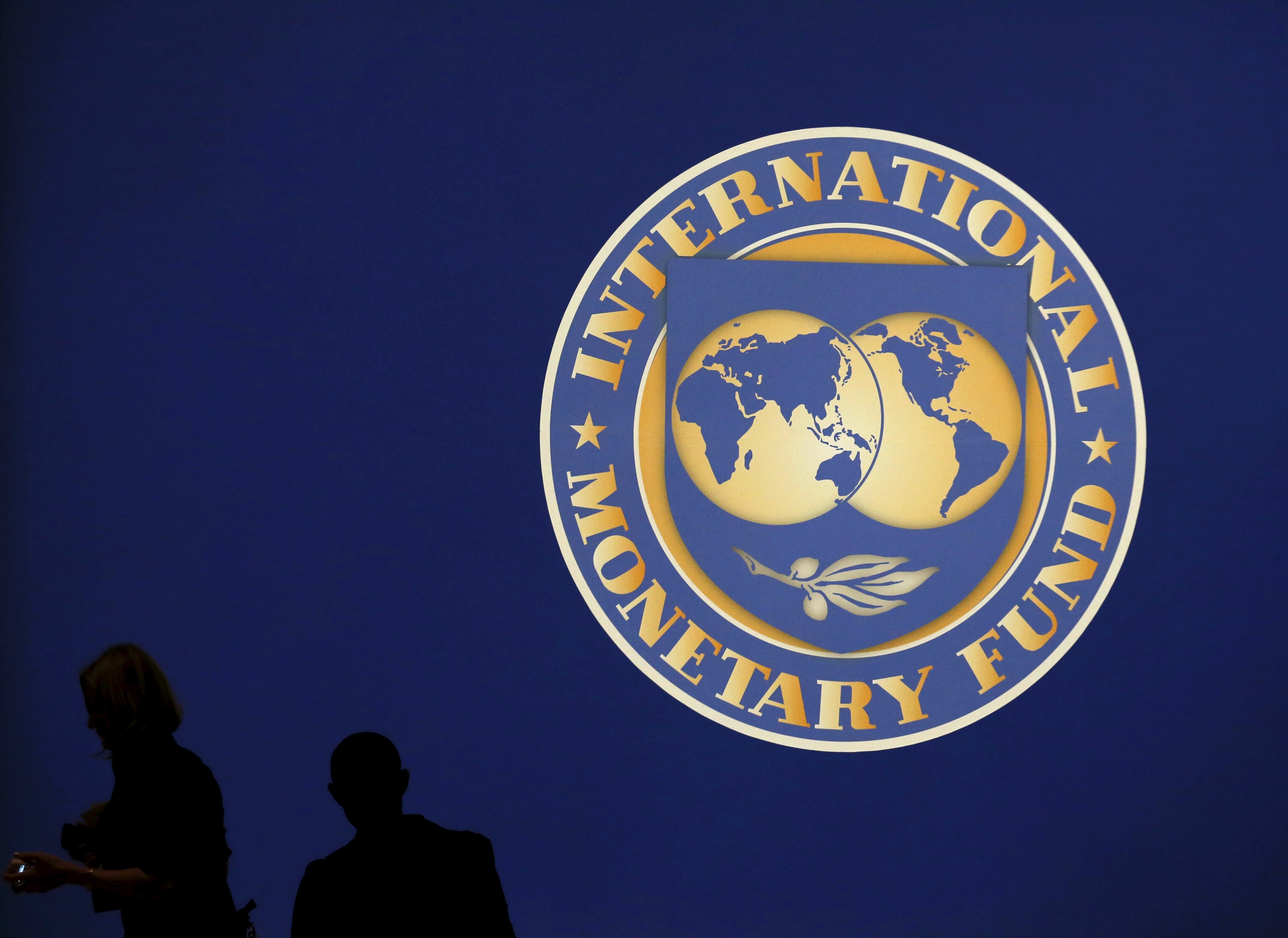 Visitors are silhouetted against the logo of the International Monetary Fund at the main venue for the IMF and World Bank annual meeting in Tokyo in this October 10, 2012 file photo. Even as the International Monetary Fund prepares to accept China's yuan in its basket of reserve currencies, a major diplomatic victory for Beijing's campaign to internationalise the currency, foreign companies are growing more sceptical. Thanks to recent reforms in China and the endorsement of key European governments, including Britain during a visit by President Xi Jinping last month, the yuan looks increasingly likely to find its way into the IMF reserve basket, known as Strategic Drawing Rights (SDR). REUTERS/Kim Kyung-Hoon/Files
