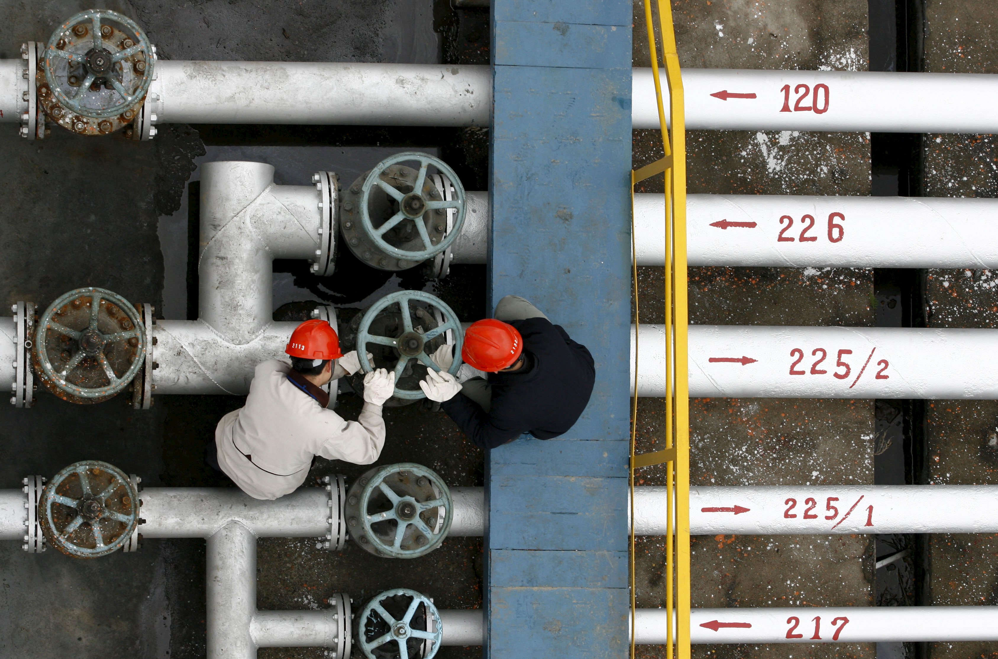 Labourers work at a refinery in Jingmen, in central China's Hubei province, in this December 8, 2006 file photo. Iran's oil sales look to be headed towards a six-month low in September 2015, down 16 percent from August, with tanker loading data showing Tehran is struggling to boost crude exports despite optimism over the landmark deal on its nuclear programme. The OPEC producer has been getting lukewarm responses from Asian buyers to offers of discounts in return for increased purchases as it tries to regain market share lost to rivals such as Saudi Arabia over the last 3-1/2 years of Western sanctions. August and September loadings - for arrivals in September and October - suggest imports by its main buyers in Asia are set to fall a second straight month in September, due to a seasonal drop in demand at the end of summer and as China takes its lowest volume of Iranian crude in nearly a year. REUTERS/Stringer/FilesCHINA OUT. NO COMMERCIAL OR EDITORIAL SALES IN CHINA