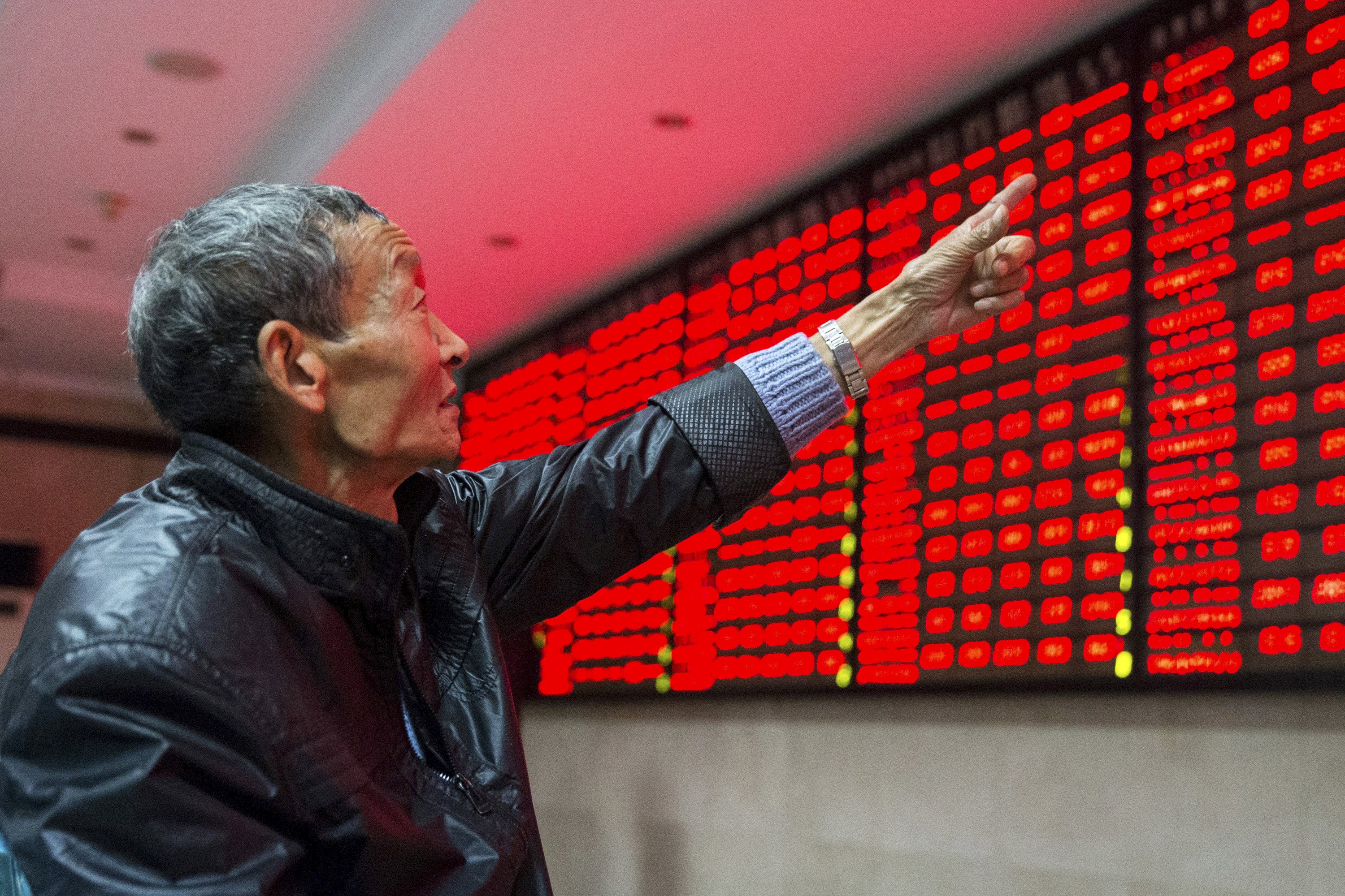 An investor points to an electronic board showing stock information as he speaks to another investor, at a brokerage house in Nanjing, Jiangsu province, China, November 19, 2015. China stocks ended higher on Thursday, with a sharp rebound in small-caps offsetting the drag from property shares and investor caution ahead of a flurry of new listings. REUTERS/China Daily CHINA OUT. NO COMMERCIAL OR EDITORIAL SALES IN CHINA