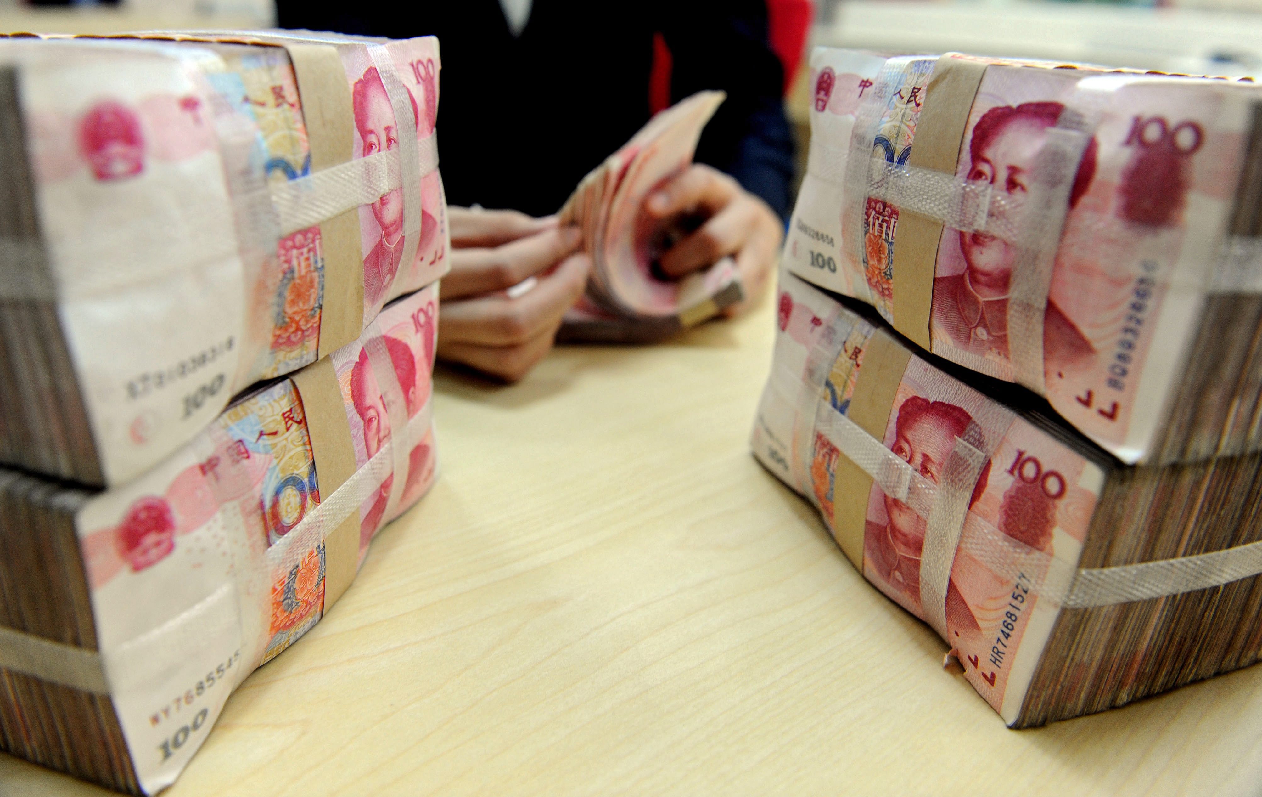 epa05049734 (FILE) A file picture dated 13 January 2010 of a bank teller counting renminbi bank notes in Shenyang, northeast China. The International Monetary Fund (IMF) on 30 November 2015 announced it is adding China's renminbi, or Yuan, to the currencies that the Washington-based crisis lender uses as a measure of value, alongside the dollar, euro, yen and pound sterling. EPA/MARK *** Local Caption *** 01987545