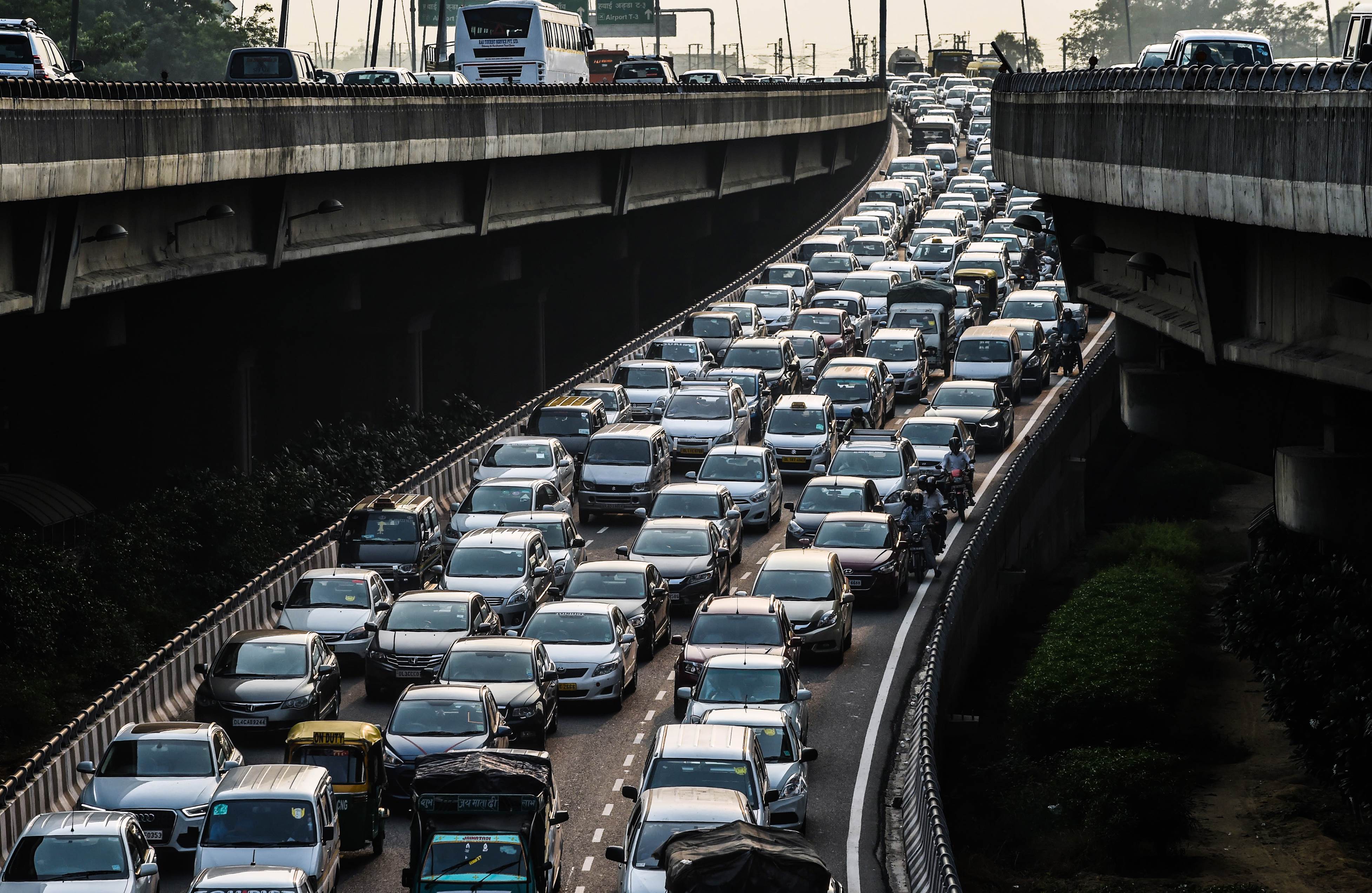 To go with Climate-warming-UN-COP21-India,FOCUS by Trudy Harris In this photo taken on October 15, 2015, a stream of cars backs up on an exit to a highway in New Delhi. India's capital, with 18 million residents, has the world's most polluted air with six times the amount of small particulate matter (pm2.5) than what is considered safe, according to the World Health Organization (WHO). The air's hazardous amount of pm2.5 can reach deep into the lungs and enter the blood, causing serious long term health effect, with the WHO warning India has the world's highest death rate from chronic respiratory diseases. India, home to 13 of the world's top 20 polluted cities, is also the third largest emitter of greenhouse gases behind the United States and China. In Delhi, the air pollution is due to vehicle traffic including cargo trucks running on low-grade diesel, individual fires that residents burn in winter, crop being burnt by farmers in neighboring states, and construction site dust. Burnin
