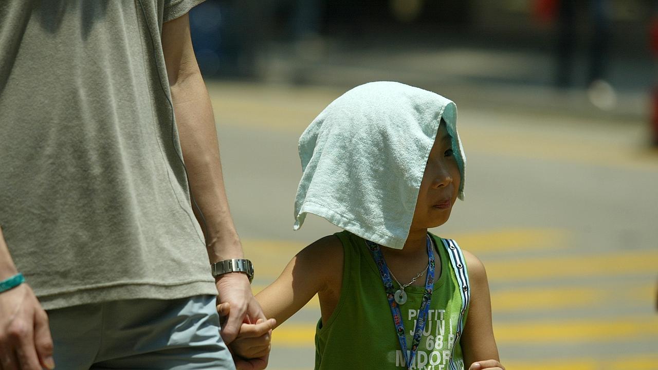 A child covers his head against the strong sunlight. The heatwave in Hong Kong reached 34 degrees in the afternoon. 18 July 2005