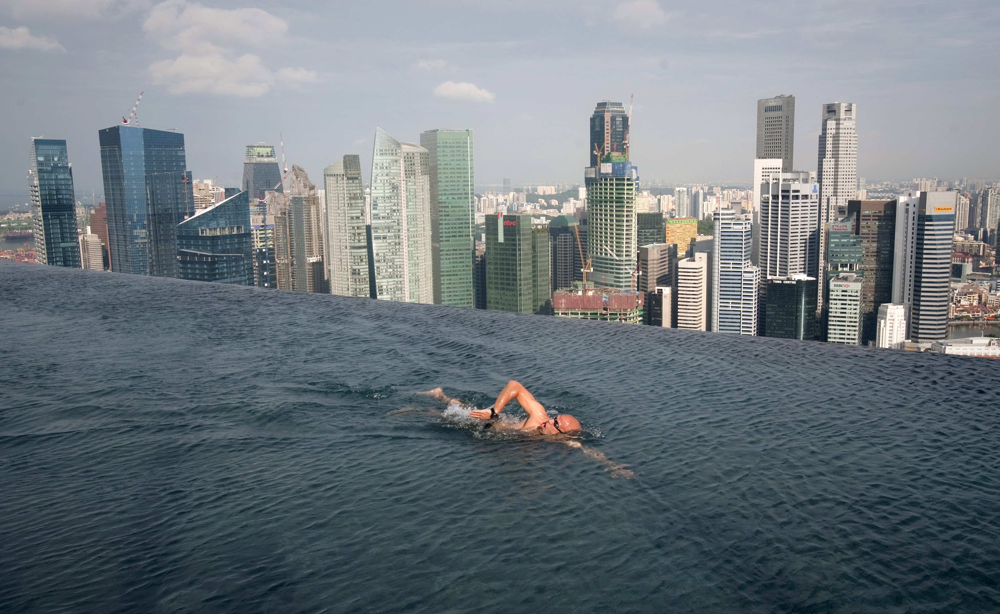 A guest swims in the infinity pool of the Skypark that tops the Marina Bay Sands hotel towers in Singapore, in this June 24, 2010 file photo. Singapore economy grew much faster than initially estimated in the third quarter thanks to a solid service sector, data showed on November 25, 2015, but the government softened its growth outlook for the year amid sluggish global demand. REUTERS/Vivek Prakash/Files