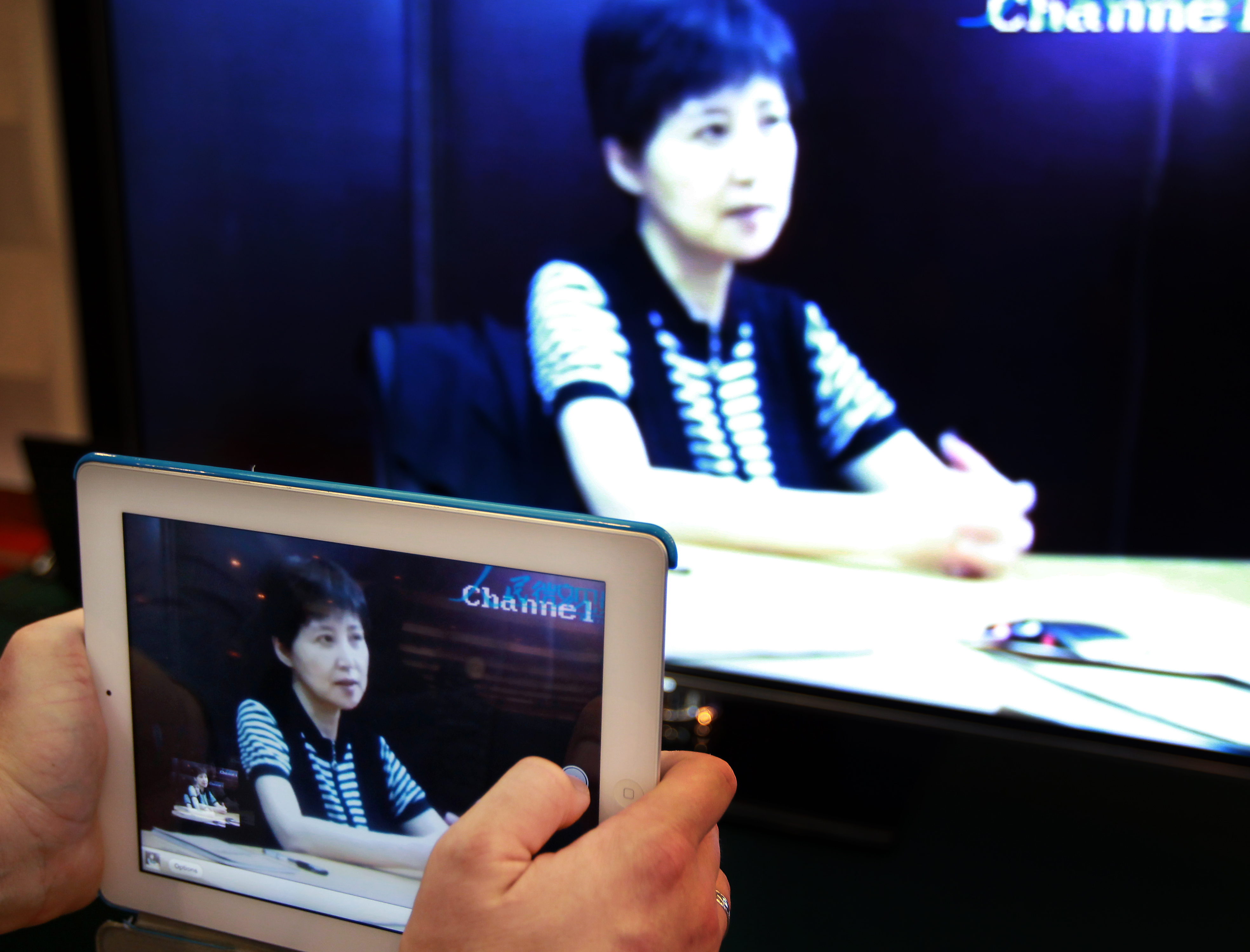 A reporter takes photos of the TV screen showing Bogu Kailai, wife of Bo Xilai, making testimony on the second day of Bo Xilai trial in Jinan, Shandong province. 23AUG13 == Photo by Simon Song ==
