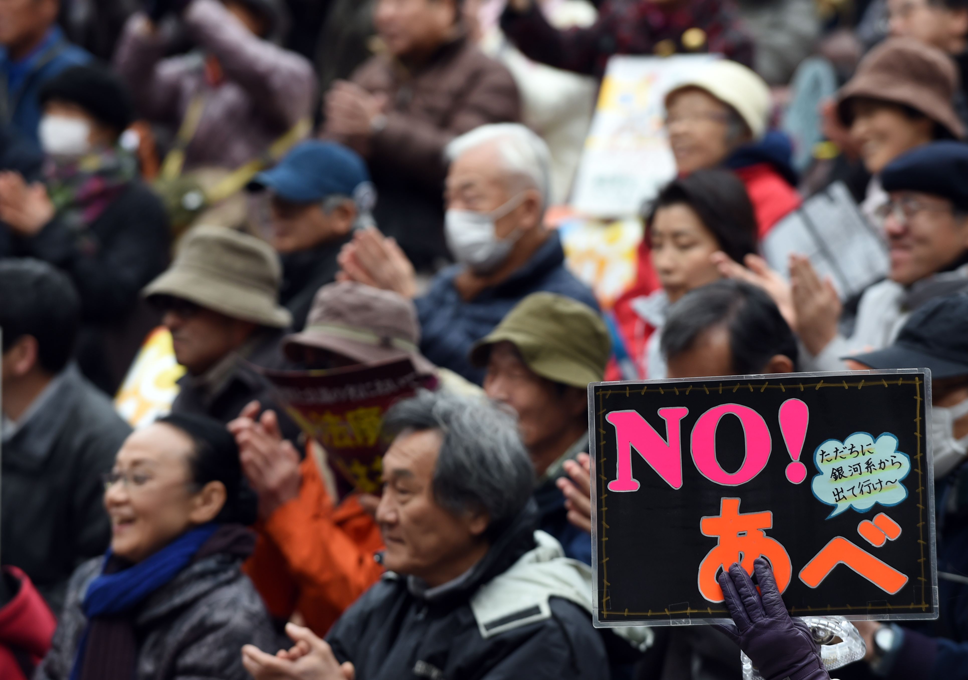 A protester holds a banner saying "No Abe" during a protest rally in Tokyo on December 6, 2015. Thousands of protesters held a "Keep Calm and No War" rally and demonstration march to protest against the contentious security bills, opening the door for Japanese troops to engage in combat overseas for the first time since the end of World War II. AFP PHOTO / TOSHIFUMI KITAMURA