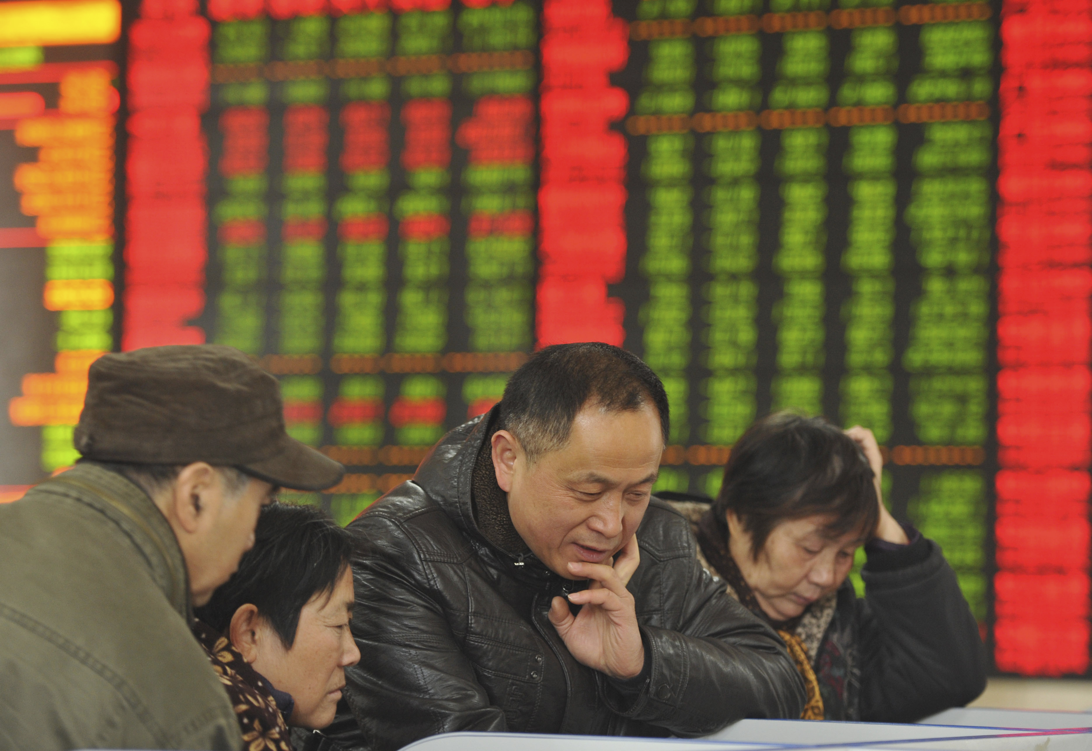 FILE - In this Friday, Nov. 27, 2015, file photo, Chinese investors monitor stock prices at a brokerage house in Fuyang in central China's Anhui province. China's sharp economic slowdown and its surprise decision to devalue its currency squeeze emerging economies, roil financial markets and escalate fears about the global economy was one of The Associated Press' top stories in 2015. (Chinatopix via AP) CHINA OUT