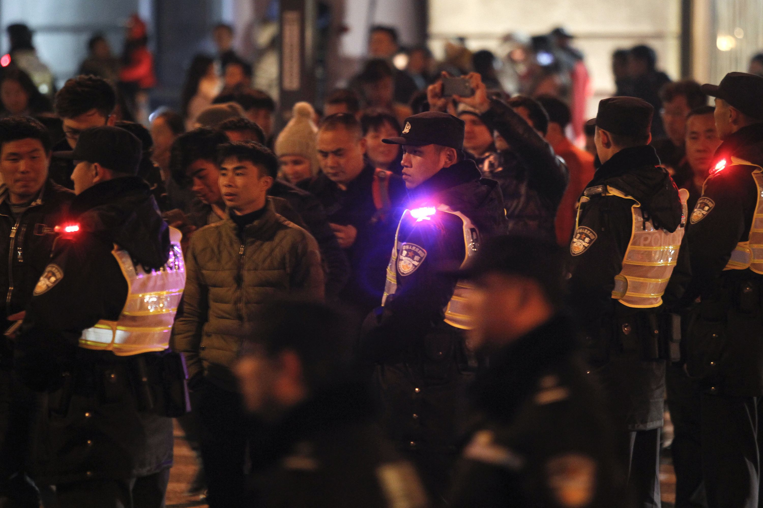 Security personnel stand on patrol on New Year's eve on the historic riverfront, known as "the Bund", in Shanghai on December 31, 2015. China's commercial hub Shanghai stepped up security along its famed waterfront on December 31, seeking to prevent the crowds that caused a crush which killed 36 people on New Year's Eve a year ago. CHINA OUT AFP PHOTO