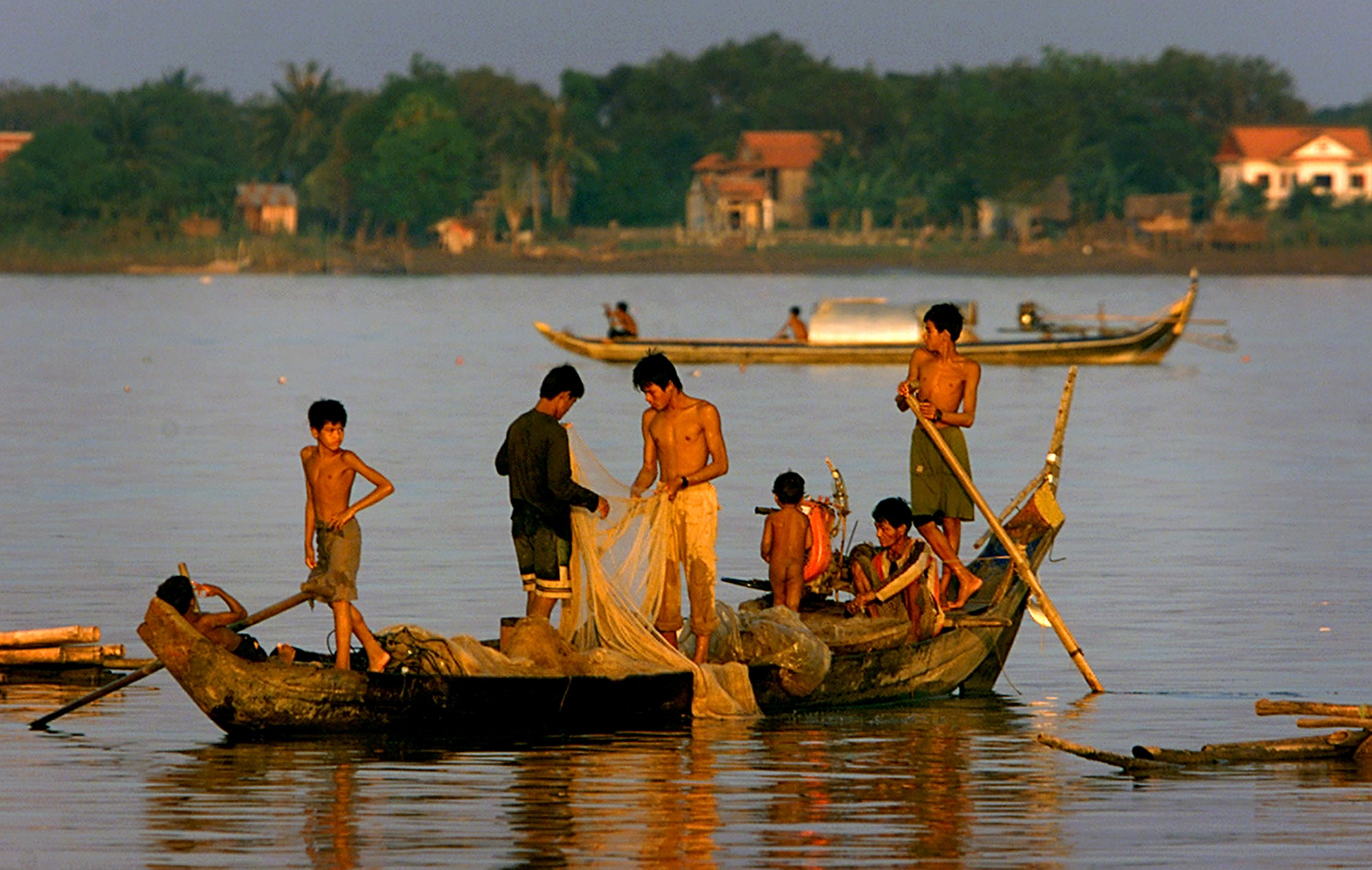 Cambodian boys fish from their small boat next to the community where they live on the Mekong River in Phnom Penh, Cambodia, Oct. 25, 2002. China's moves to dam and blast the Mekong River are arousing fears and protests that one of the world's last great untamed waterways will prove unable to sustain the millions who have depended on its bounty for centuries. (AP Photo/Andy Eames)