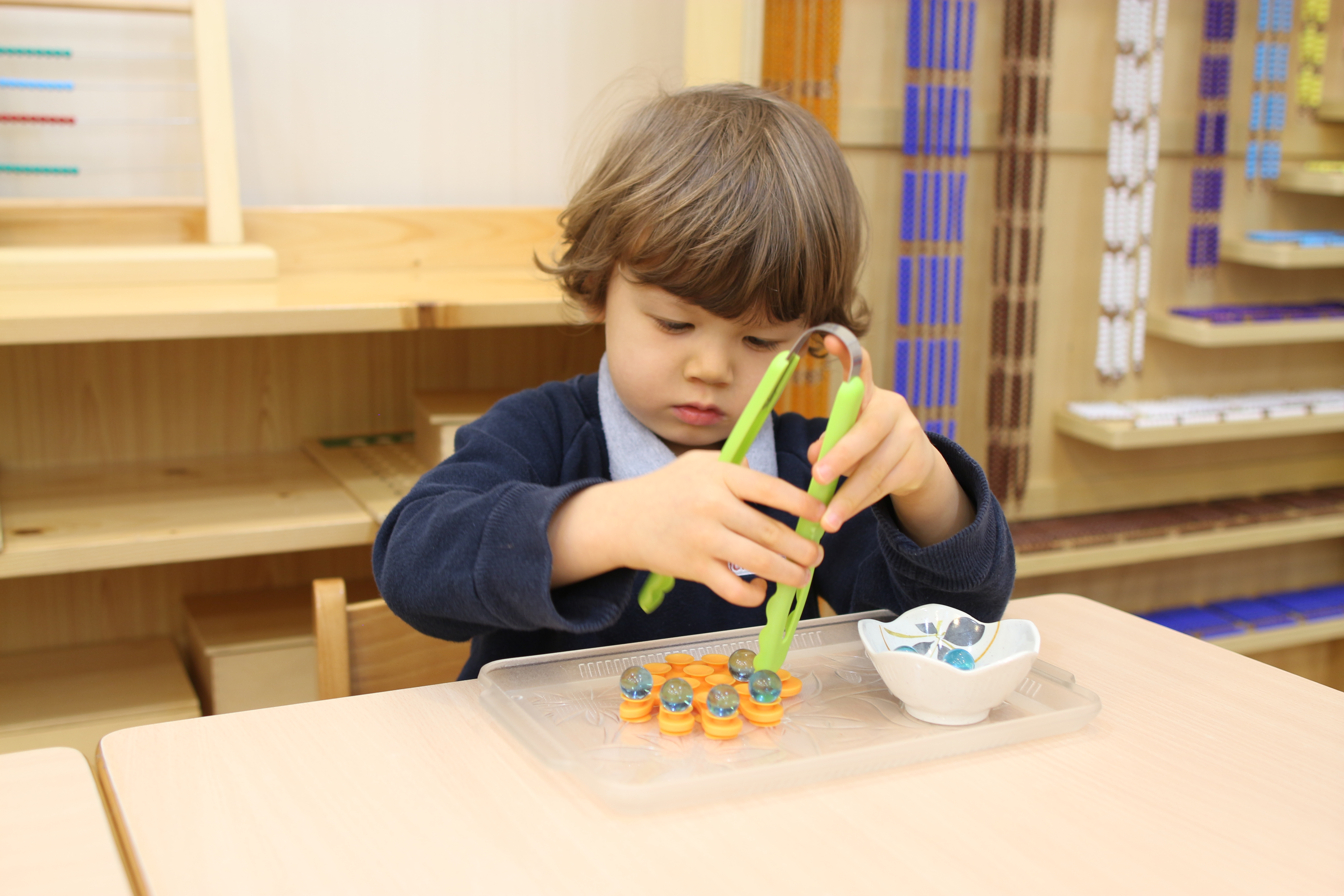 A student doing a hands-on motor control task at the Island Children’s Montessori International Nursery and Kindergarten. [2015 FEATURES EDUCATION] __[Early childhood education and school readiness]