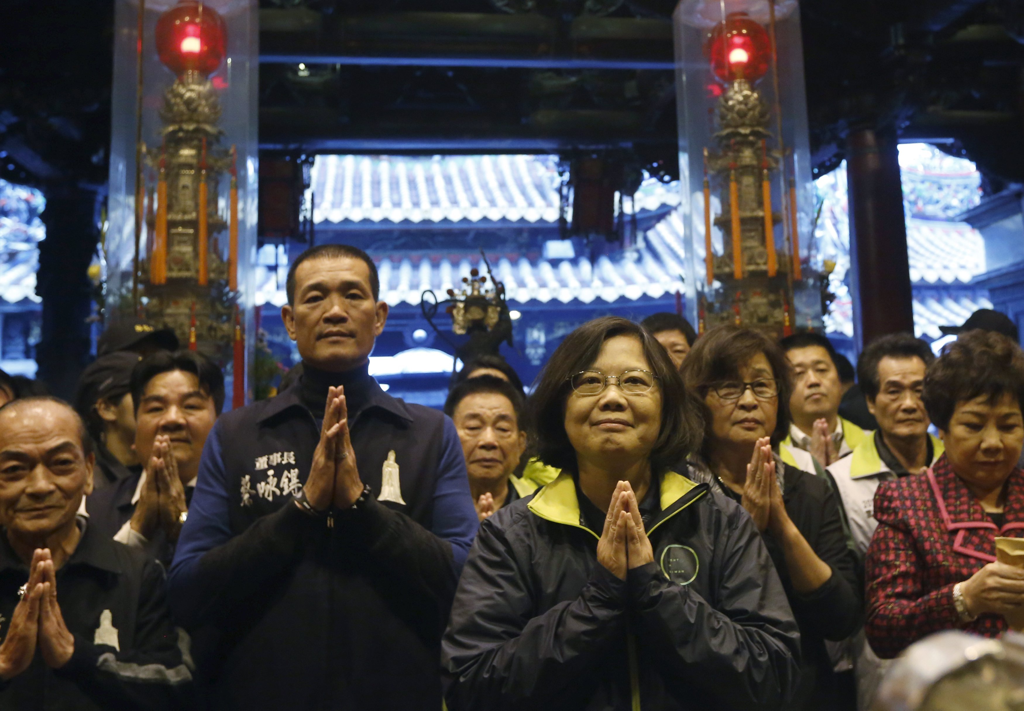 Taiwan's Democratic Progressive Party (DPP) Chairperson and presidential candidate Tsai Ing-wen (C) prays at a temple during a campaign stop in Beigang, Taiwan, January 11, 2016. REUTERS/Olivia Harris
