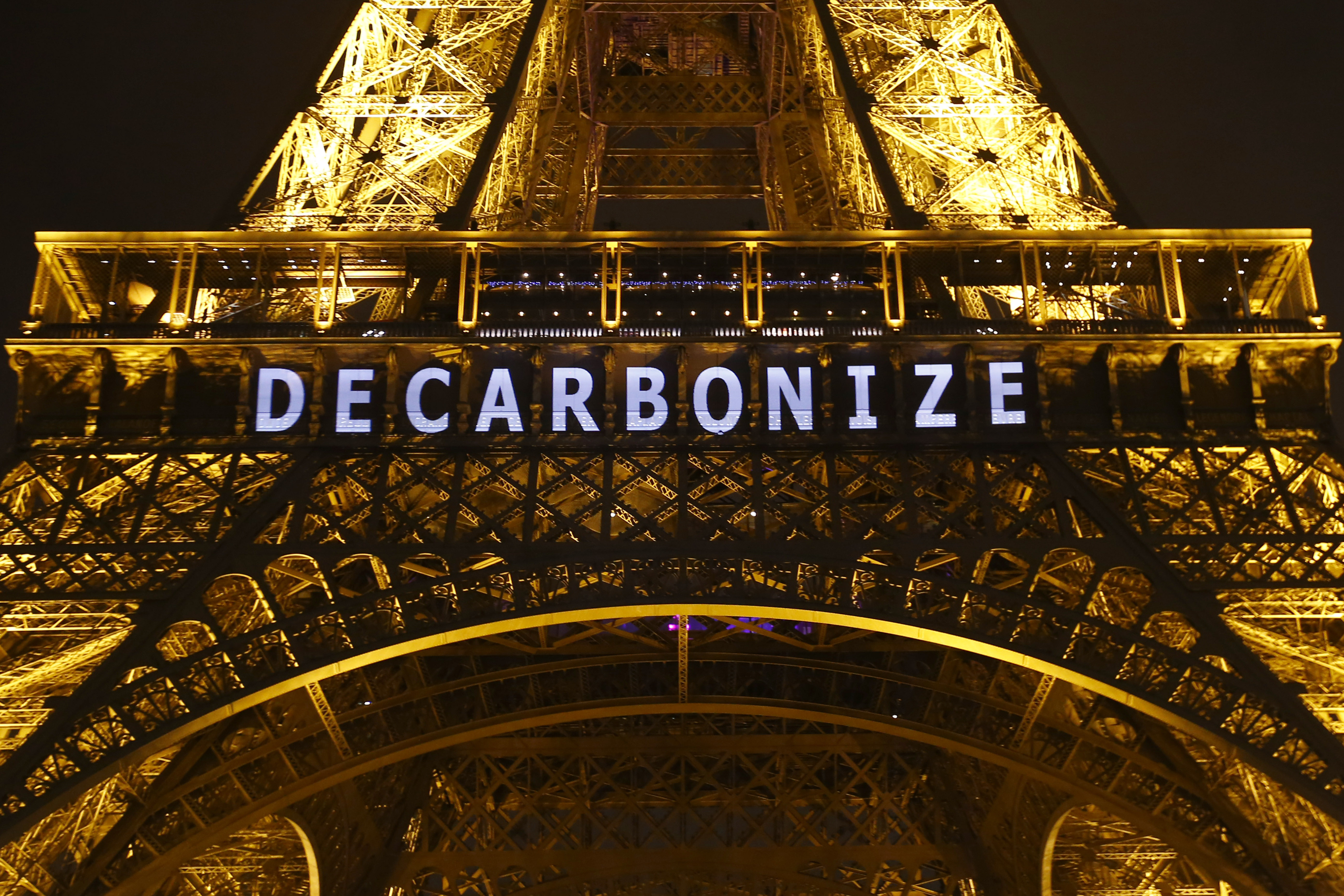 The slogan "DECARBONIZE" is projected on the Eiffel Tower as part of the COP21, United Nations Climate Change Conference in Paris, France, Friday, Dec. 11, 2015. (AP Photo/Francois Mori)