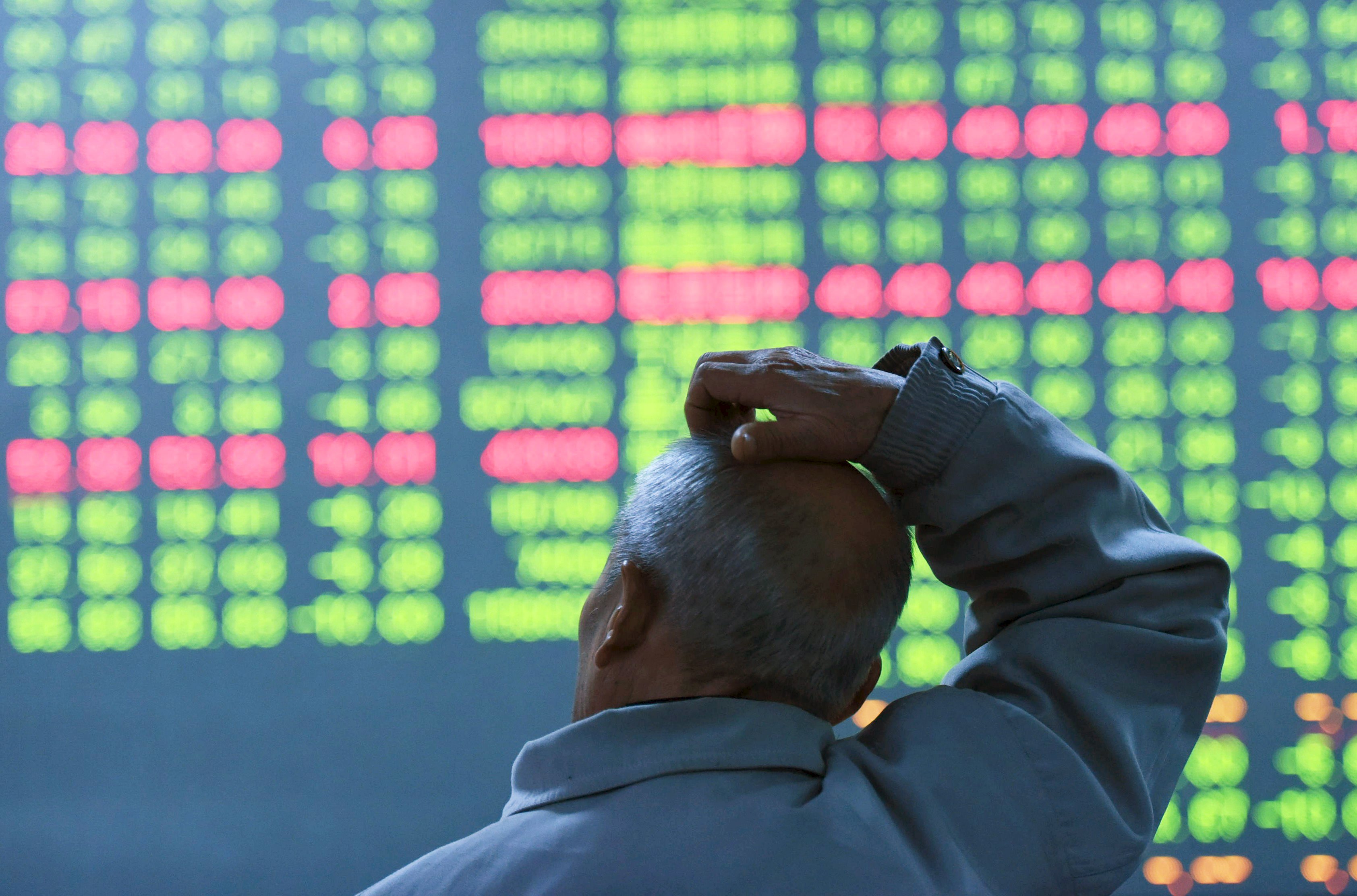 An investor looks at an electronic screen showing stock information at brokerage house in Hangzhou, Zhejiang Province, China, in this January 11, 2016 file photo. China-focused funds in Hong Kong are adopting measures to improve how they cope with liquidity shocks from Chinese markets after the securities regulator found some investors were unfairly treated during last year's market rout. REUTERS/China Daily/FilesATTENTION EDITORS - THIS PICTURE WAS PROVIDED BY A THIRD PARTY. THIS PICTURE IS DISTRIBUTED EXACTLY AS RECEIVED BY REUTERS, AS A SERVICE TO CLIENTS. CHINA OUT. NO COMMERCIAL OR EDITORIAL SALES IN CHINA.