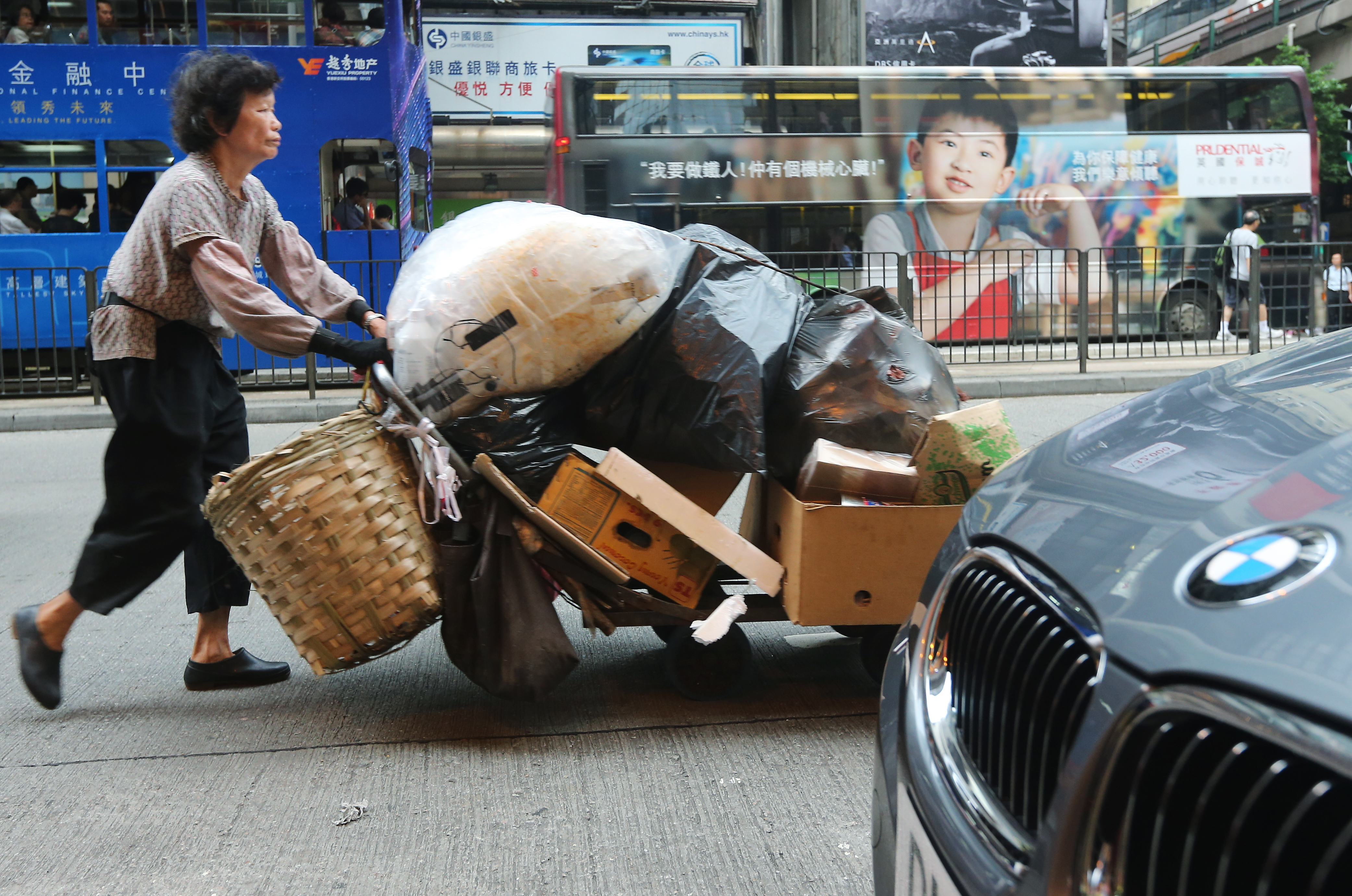 A woman pushes a trolley full of cardboard and plastic on a street of Wan Chai. The Census and Statistics Department released the results of the study on the household income distribution in Hong Kong, showing that the Gini Coefficient based on original household income of all domestic households in 2011 was 0.537, higher than 0.533 in 2006. 18JUN12