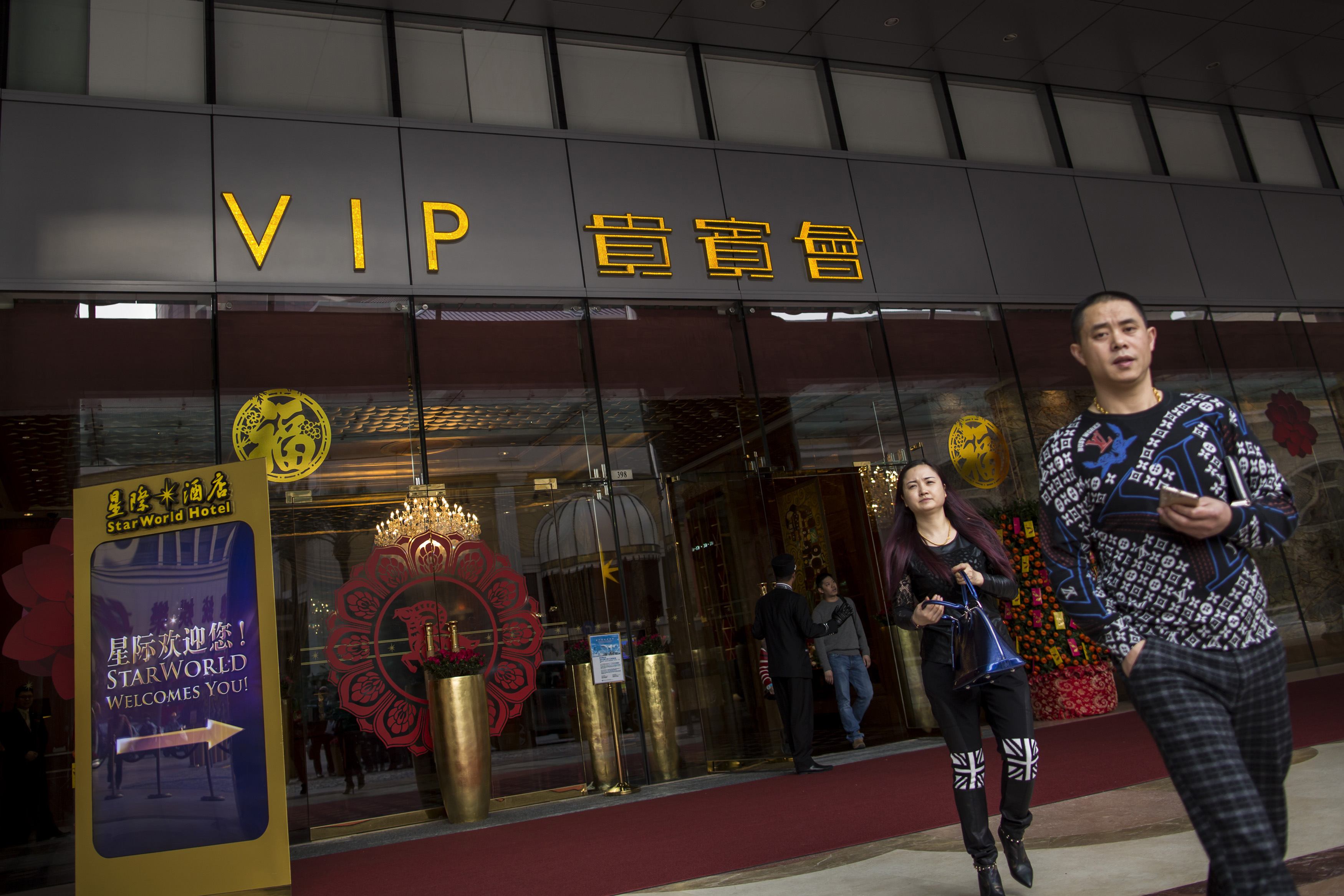Mainland Chinese visitors leave from a VIP entrance at the Starworld Macau Casino in Macau February 17, 2015. REUTERS/Tyrone Siu (CHINA - Tags: BUSINESS SOCIETY TRAVEL)