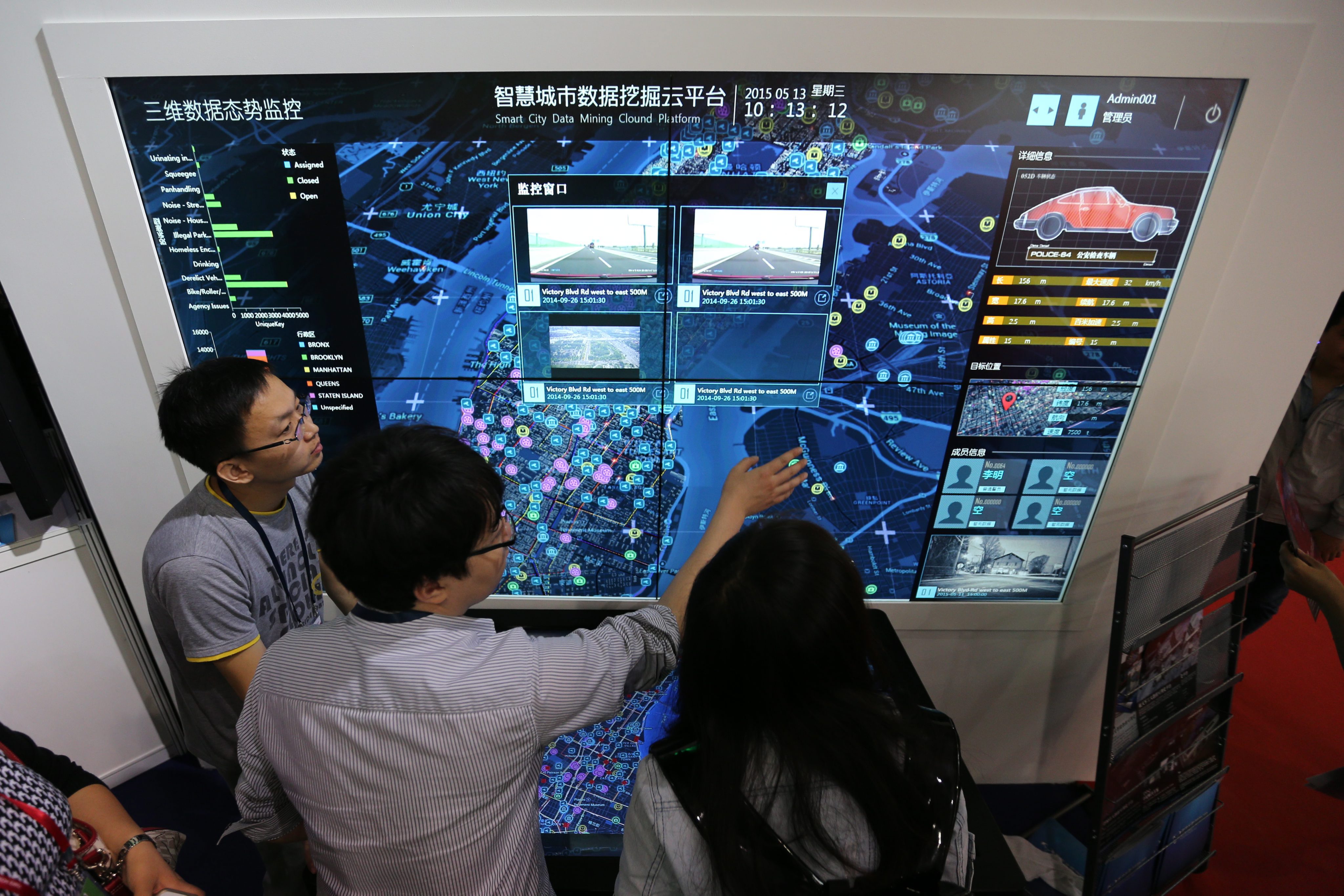 Visitors look at a screen displaying a smart city system at the 18th China Beijing International High-Tech Expo in Beijing on May 13, 2015. Photo: EPA