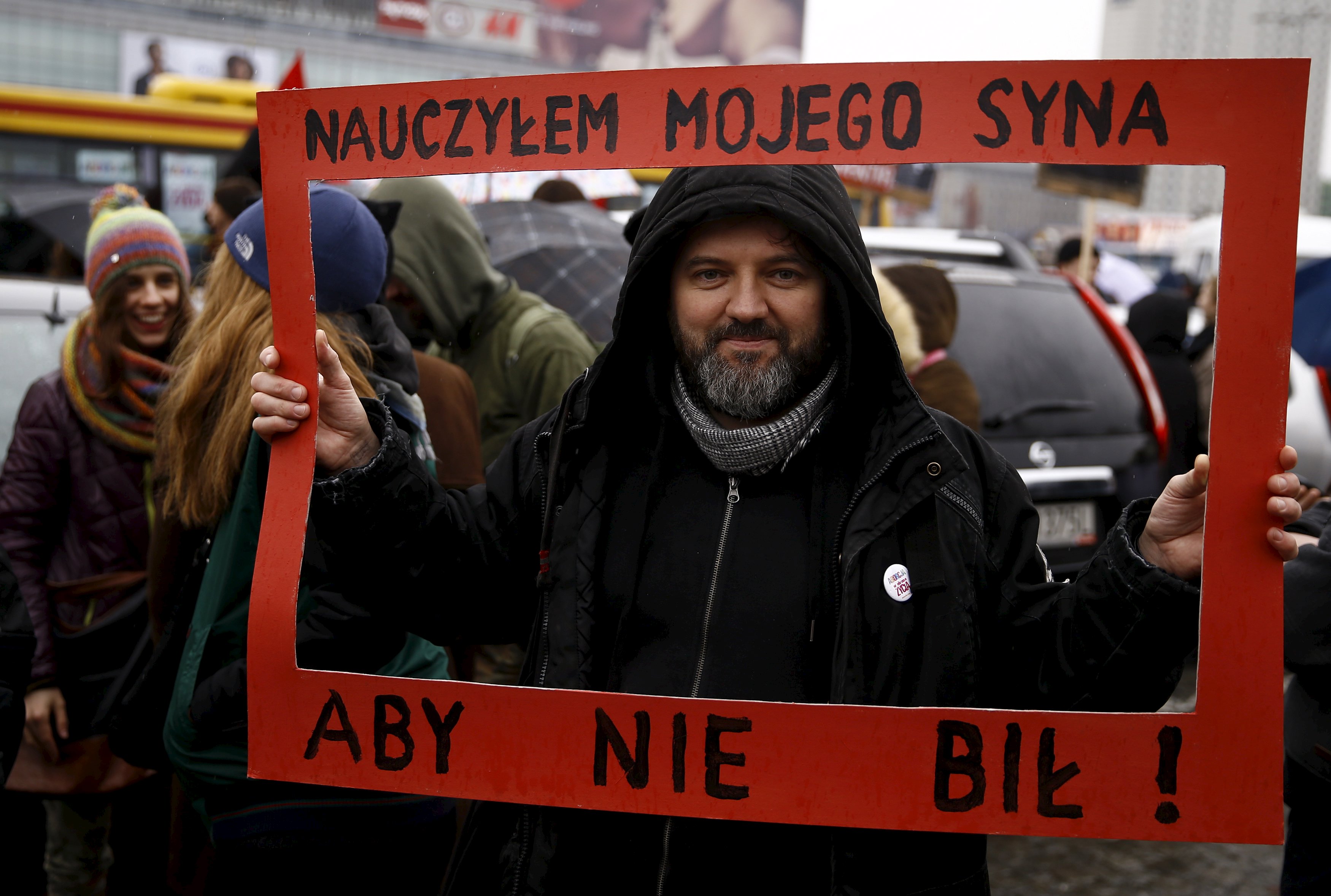 A man holds a placard which reads “I have taught my son to not beat” during an annual march in Poland ahead of International Women’s Day. Photo: Reuters