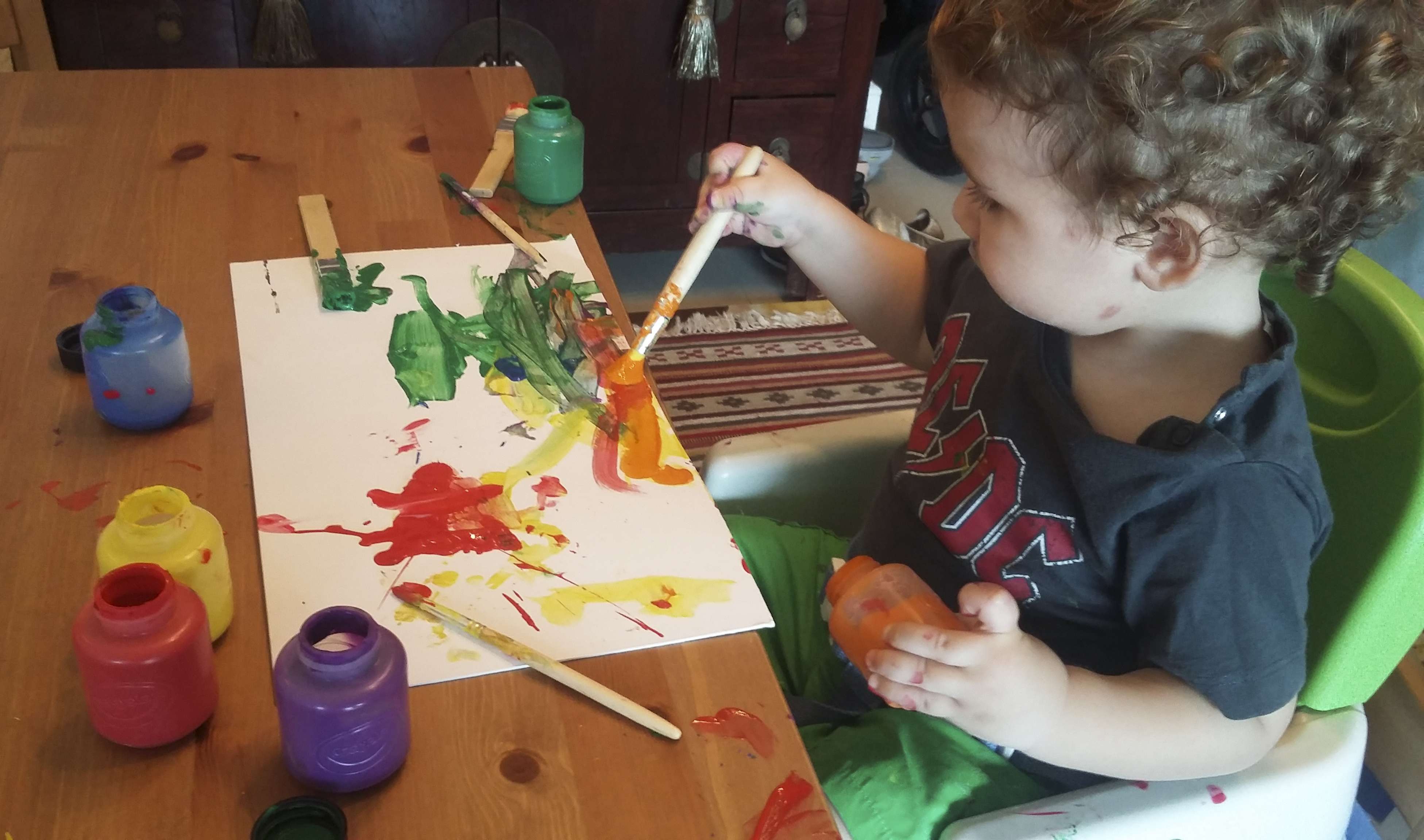 Leon, 18 months old, paints at home. We Play At Home maps out theme- and project-based activities for each child.