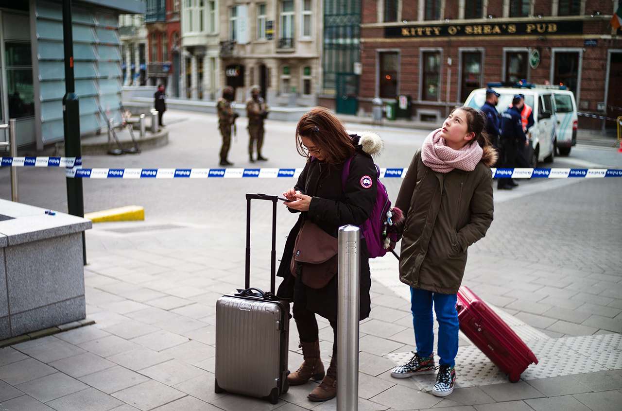 Tourists look for directions as police patrol near the European Commission after the explosion at Maelbeek Metro station. Photo: EPA