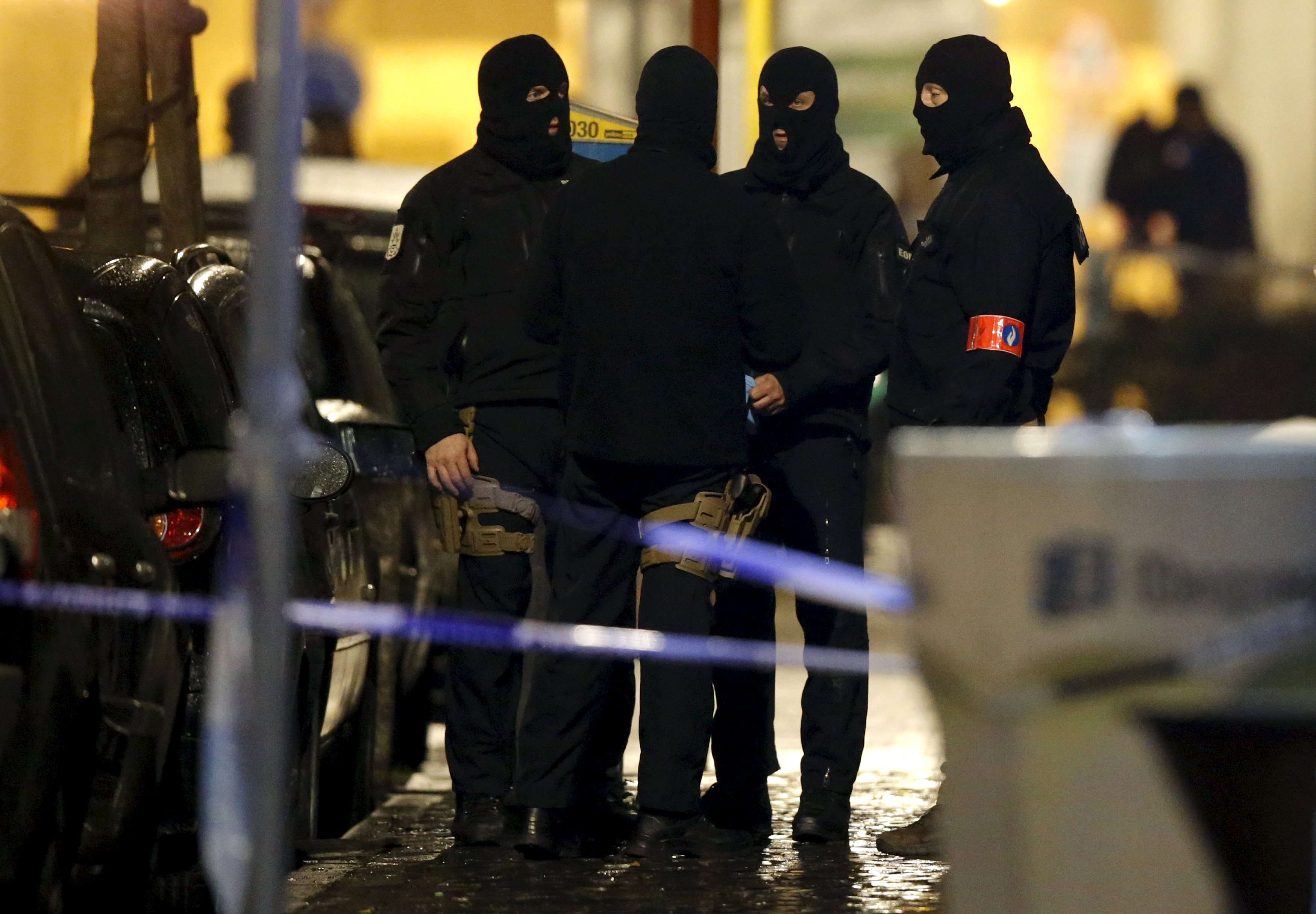 Masked Belgian police secure the entrance to a building in Schaerbeek in Brussels early on Friday. Photo: Reuters