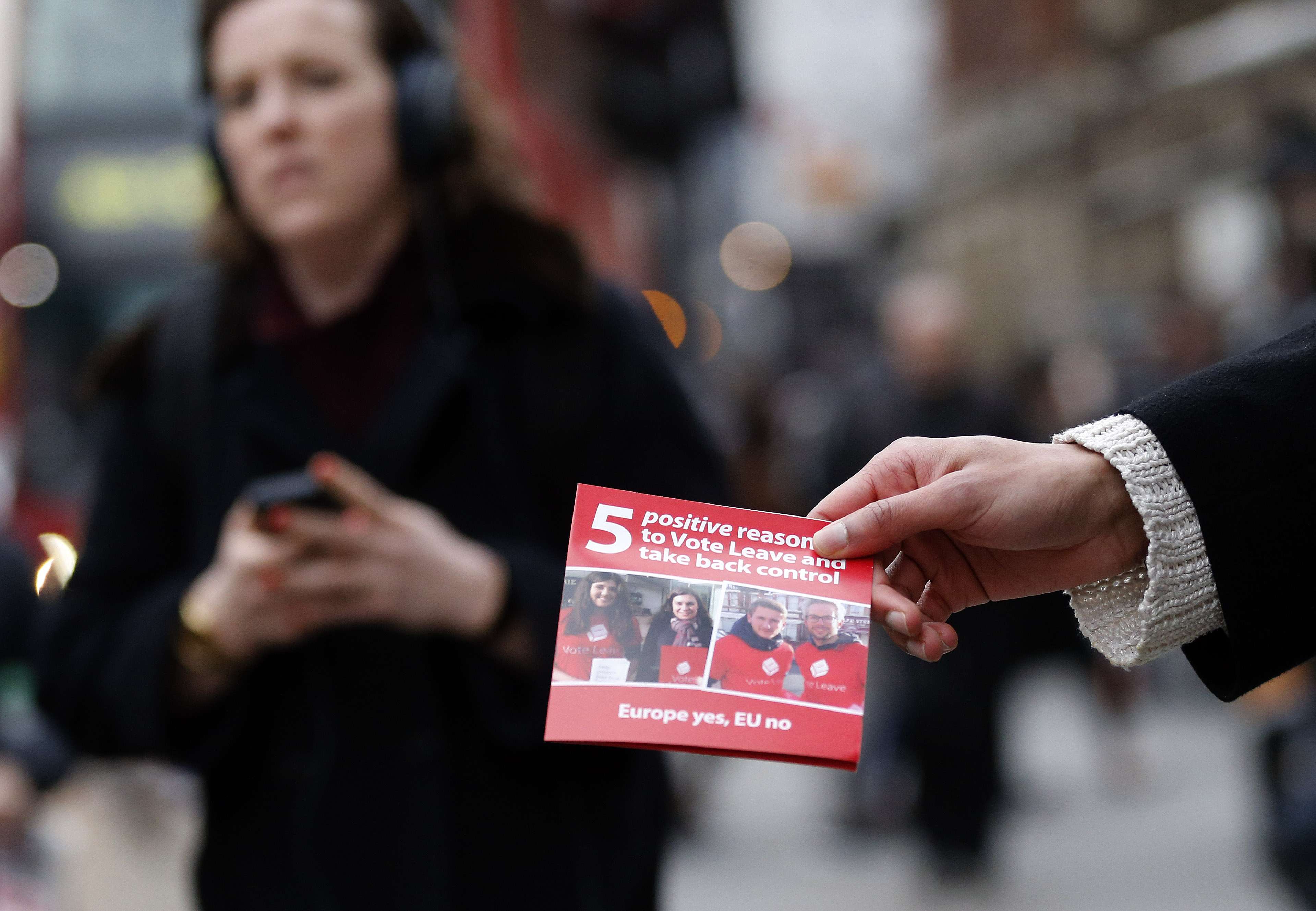 A pro-Brexit campaigner hands out leaflets at Liverpool Street station in London. Photo: AP