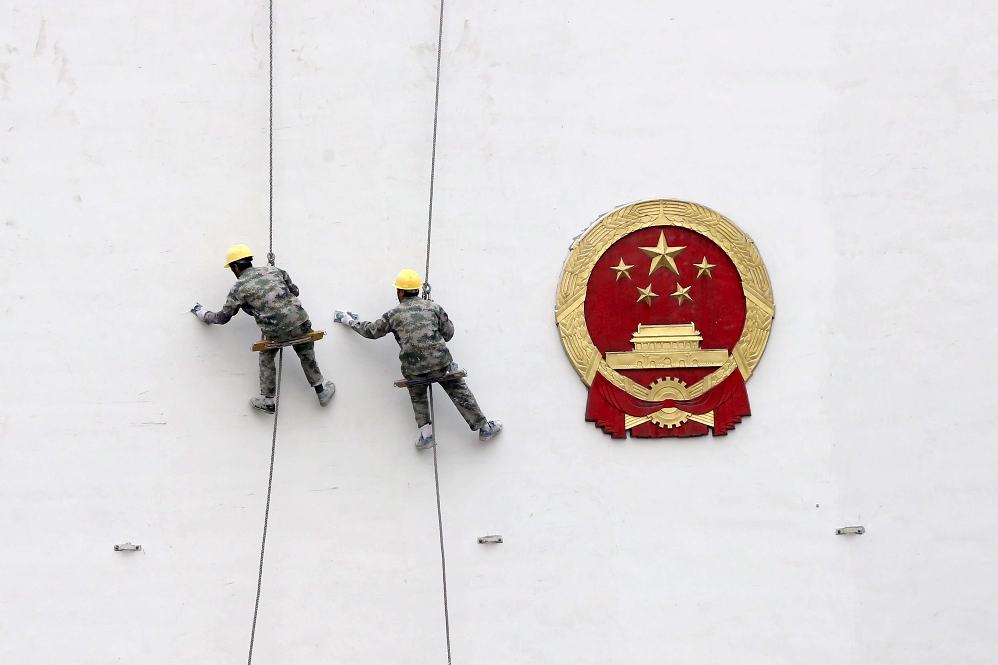 Workers paint a wall of a government building in Hangzhou, Zhejiang province. Photo: Reuters